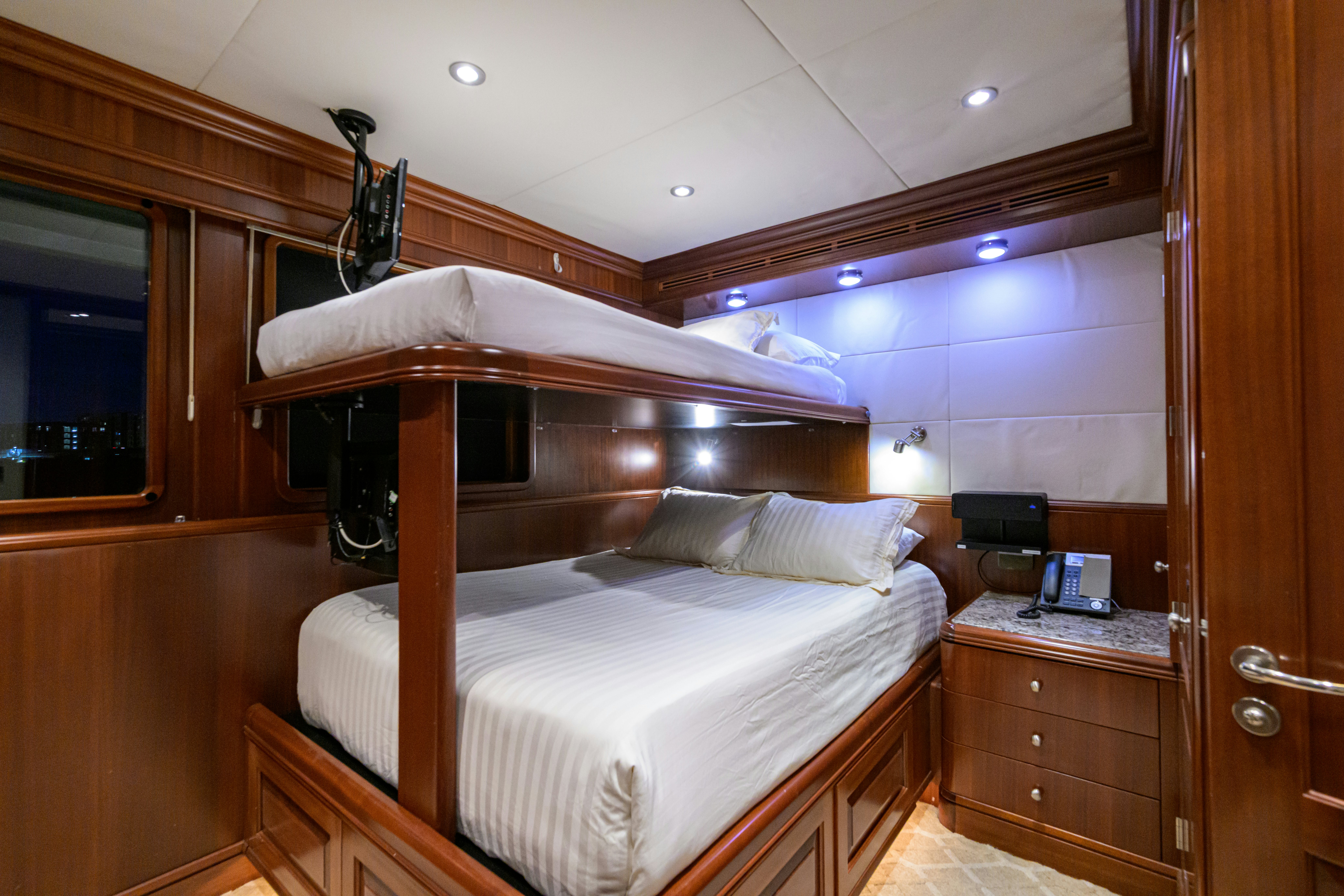 a bed with a wood headboard aboard COMPASS ROSE Yacht for Sale