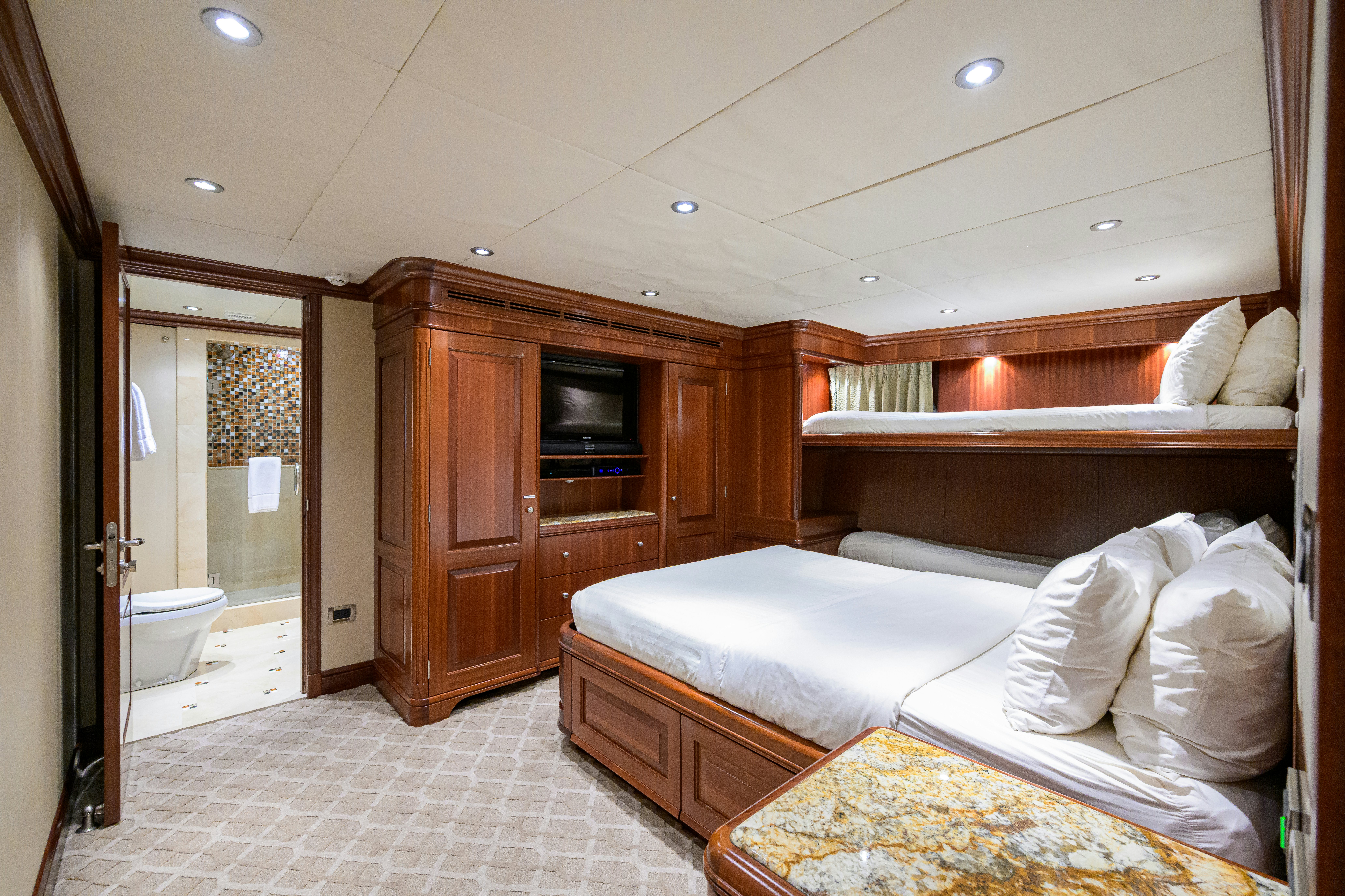 a room with a bed and a tv aboard COMPASS ROSE Yacht for Sale