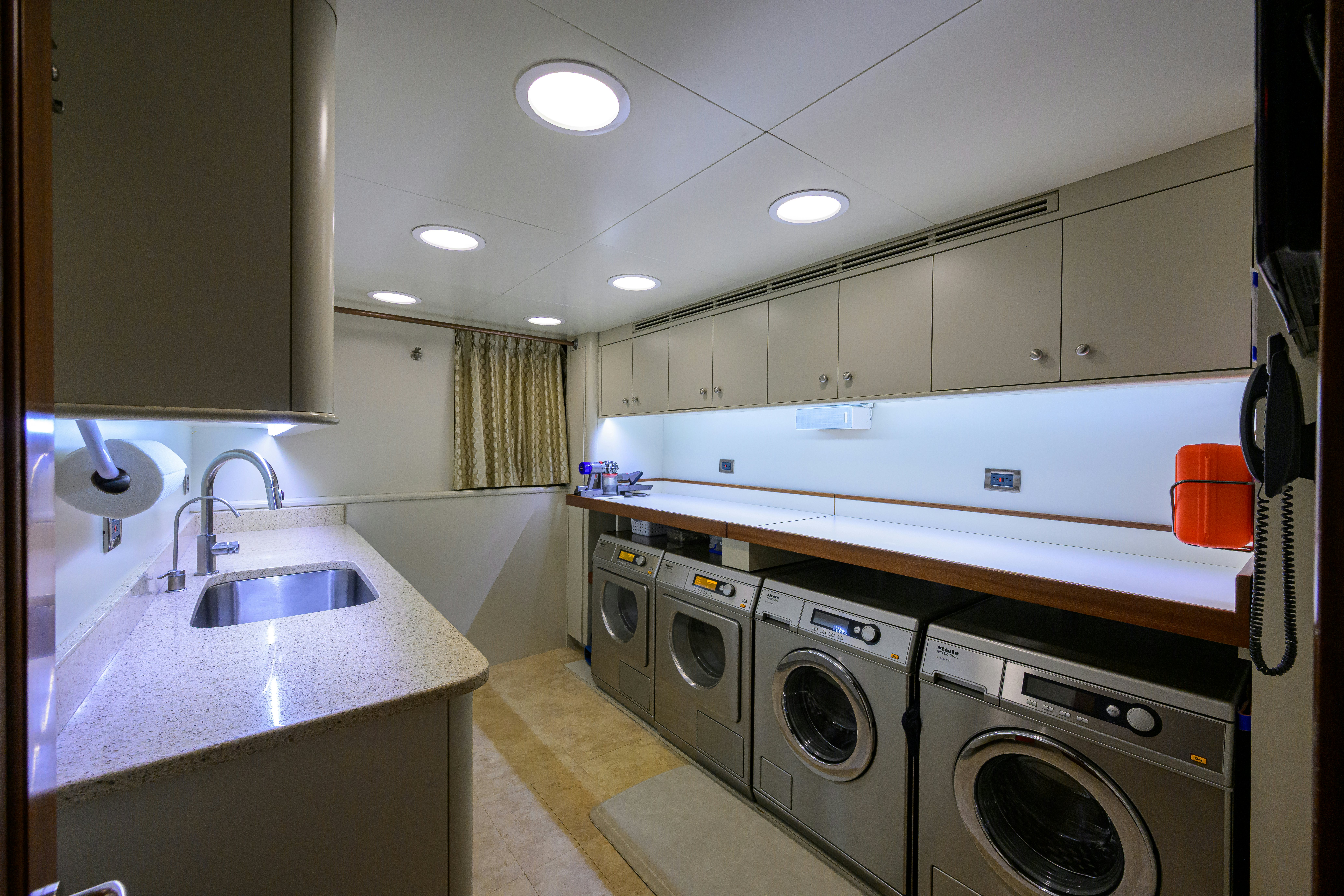 a kitchen with a sink and washing machine aboard COMPASS ROSE Yacht for Sale