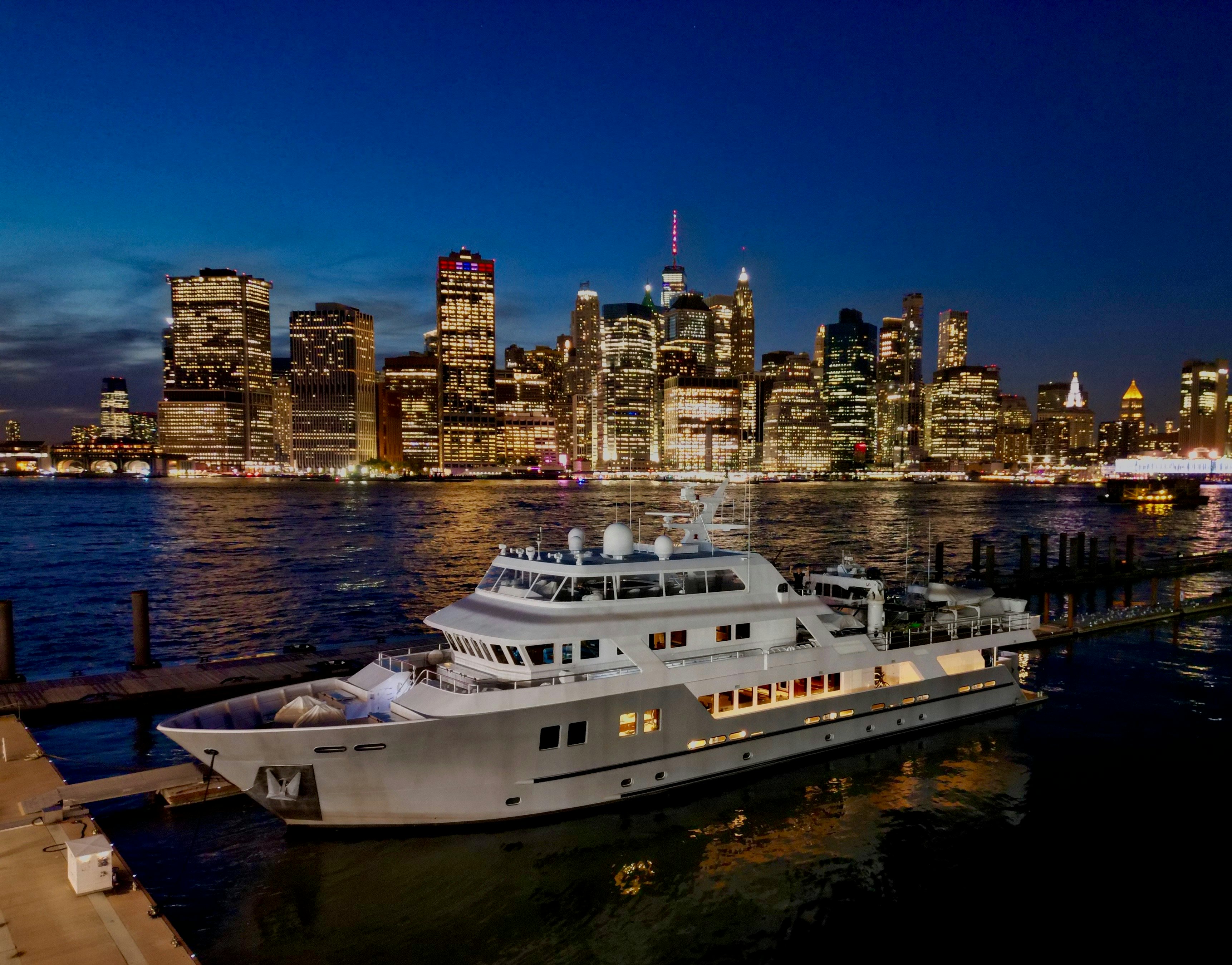 a large white boat in a harbor aboard COMPASS ROSE Yacht for Sale