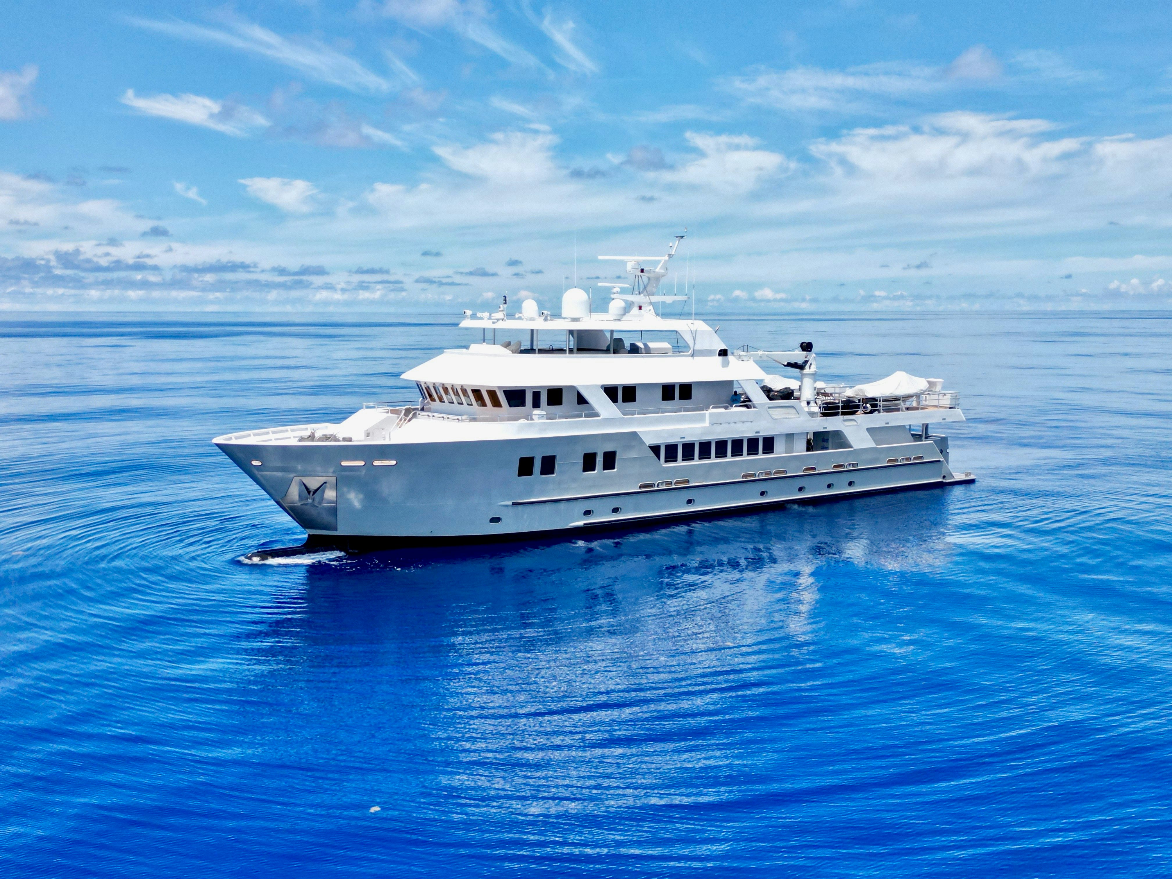 a white yacht in the water aboard COMPASS ROSE Yacht for Sale