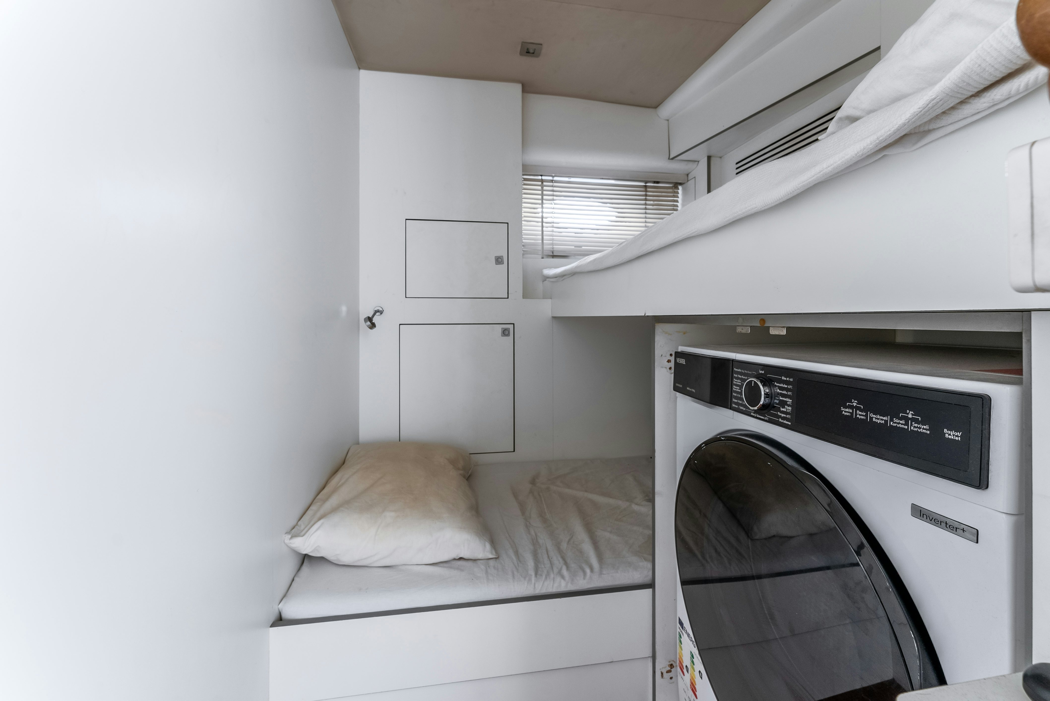 a white bedroom with a washing machine aboard LADY F Yacht for Sale