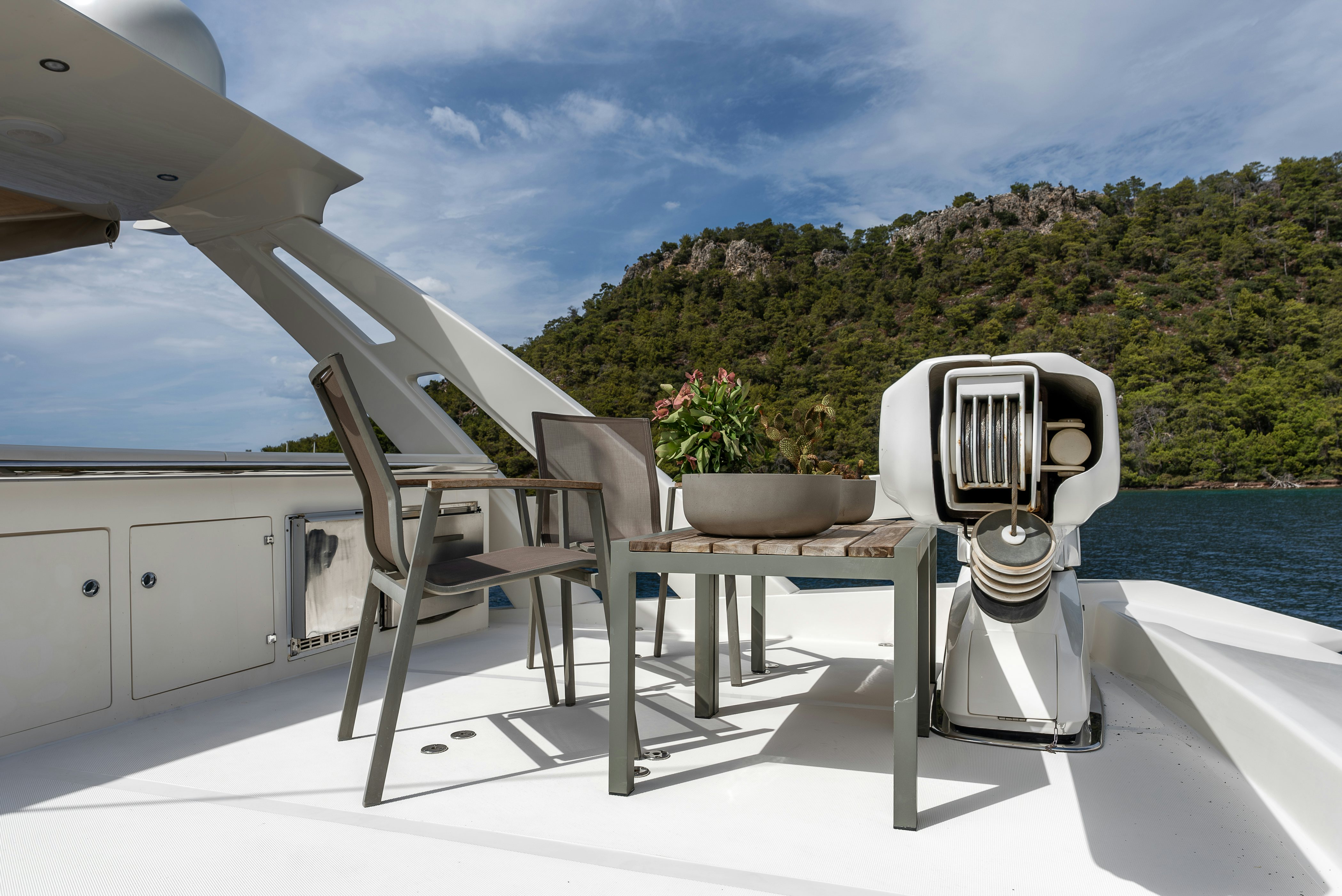 a white table and chairs on a balcony overlooking a body of water aboard LADY F Yacht for Sale