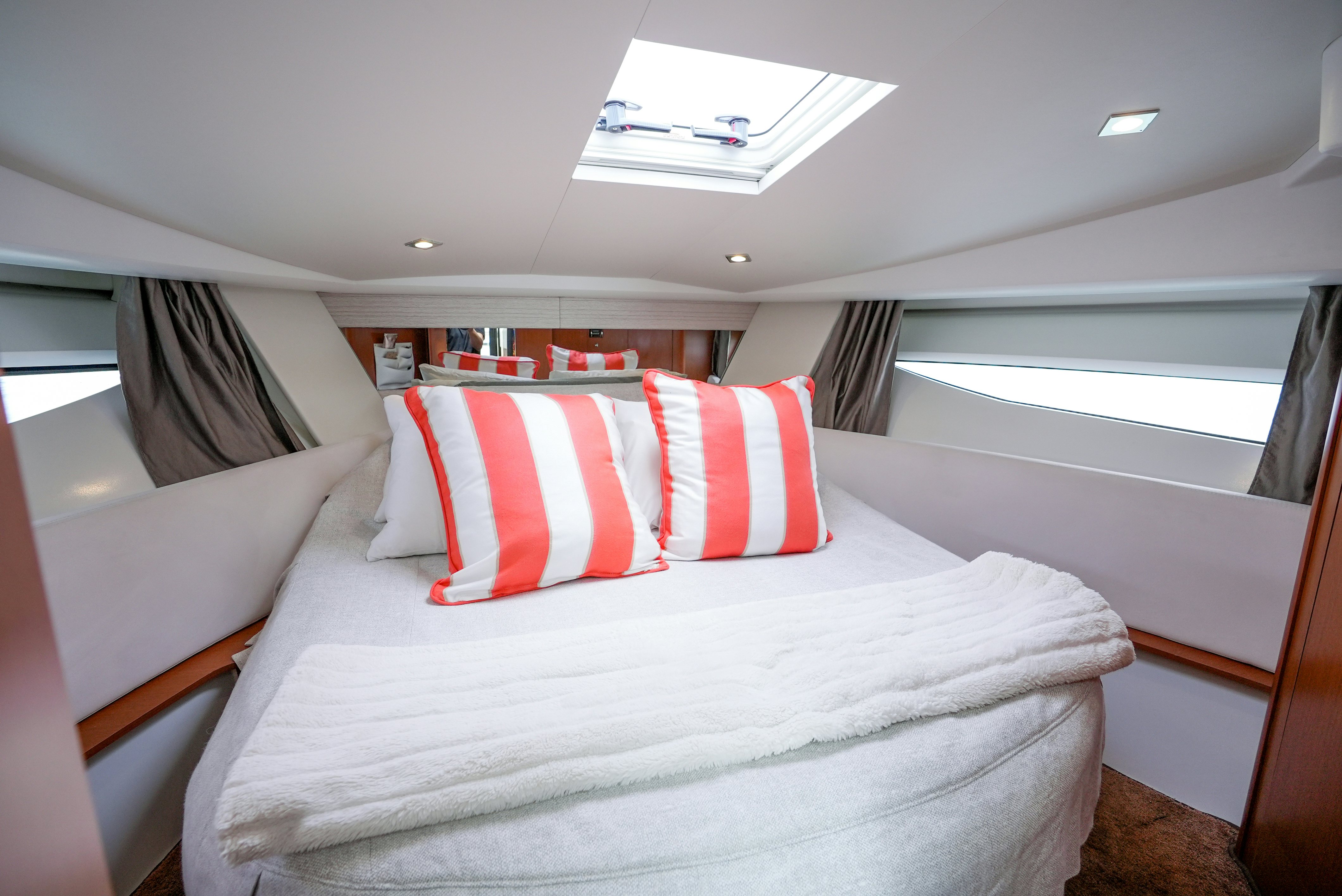 a bed with red and white pillows aboard DARK SIDE Yacht for Sale