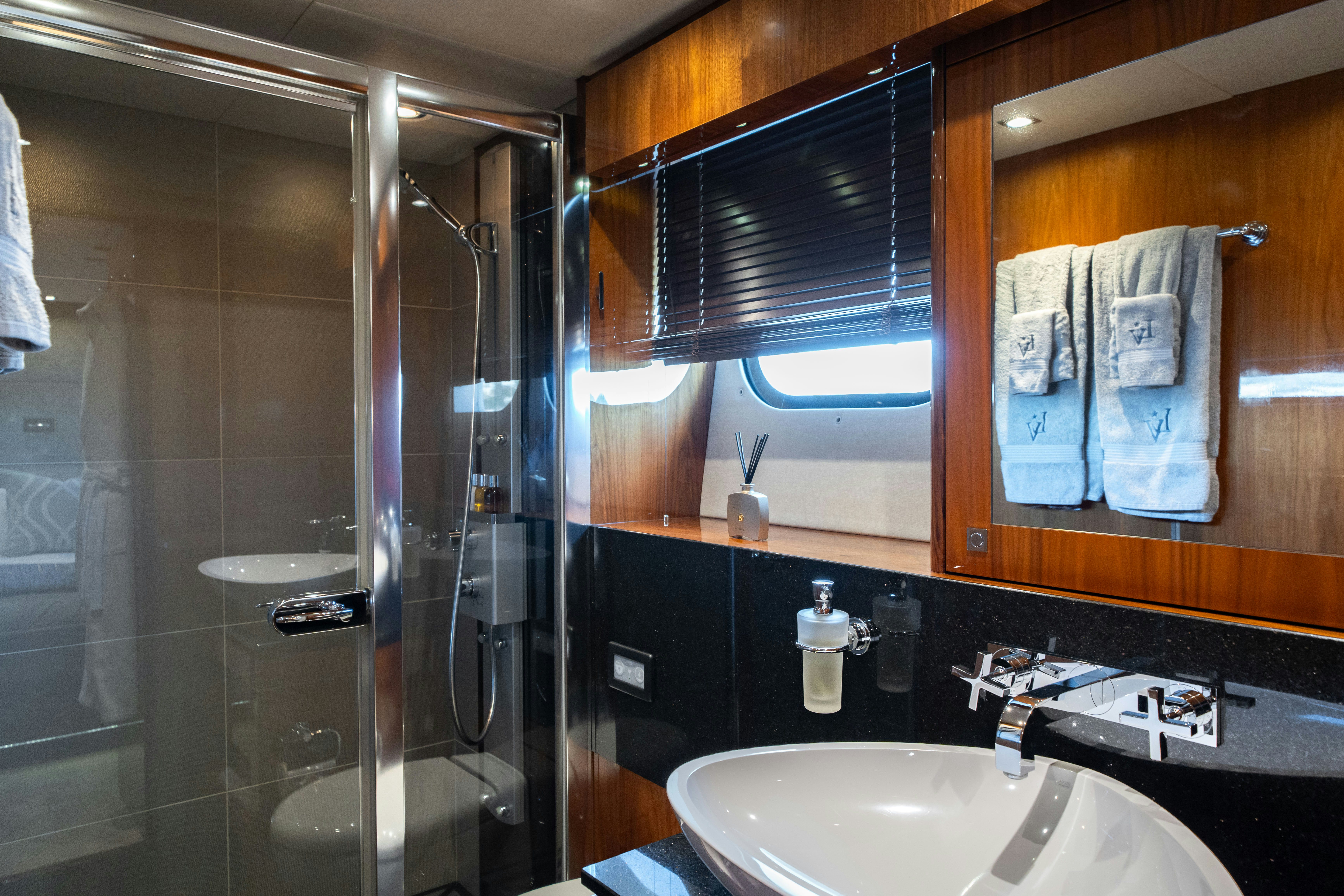a bathroom with a glass shower aboard LADY VOLANTIS Yacht for Sale
