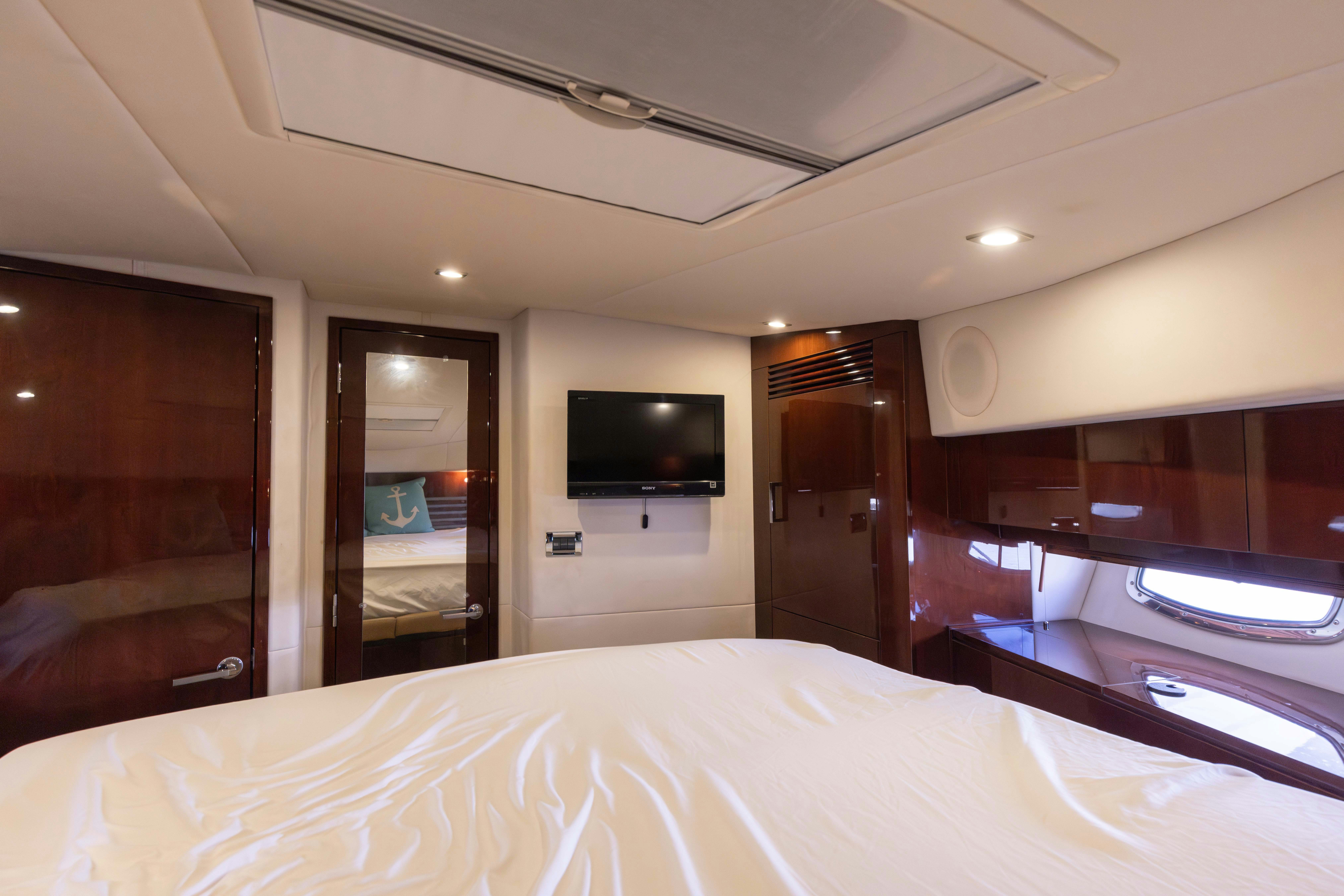 a hotel room with a bed and tv aboard KA-BAR Yacht for Sale
