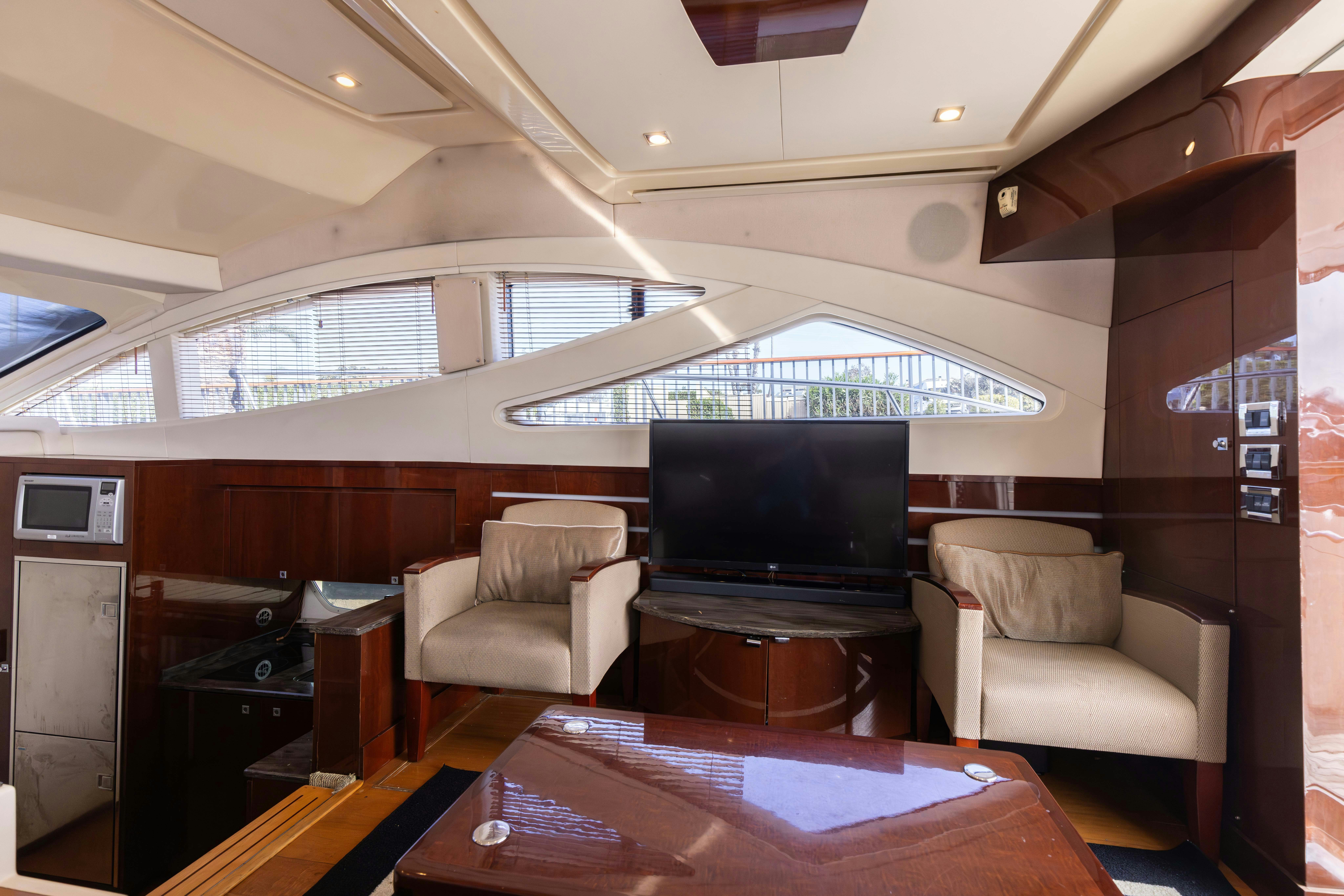 a living room with a tv and a table aboard KA-BAR Yacht for Sale