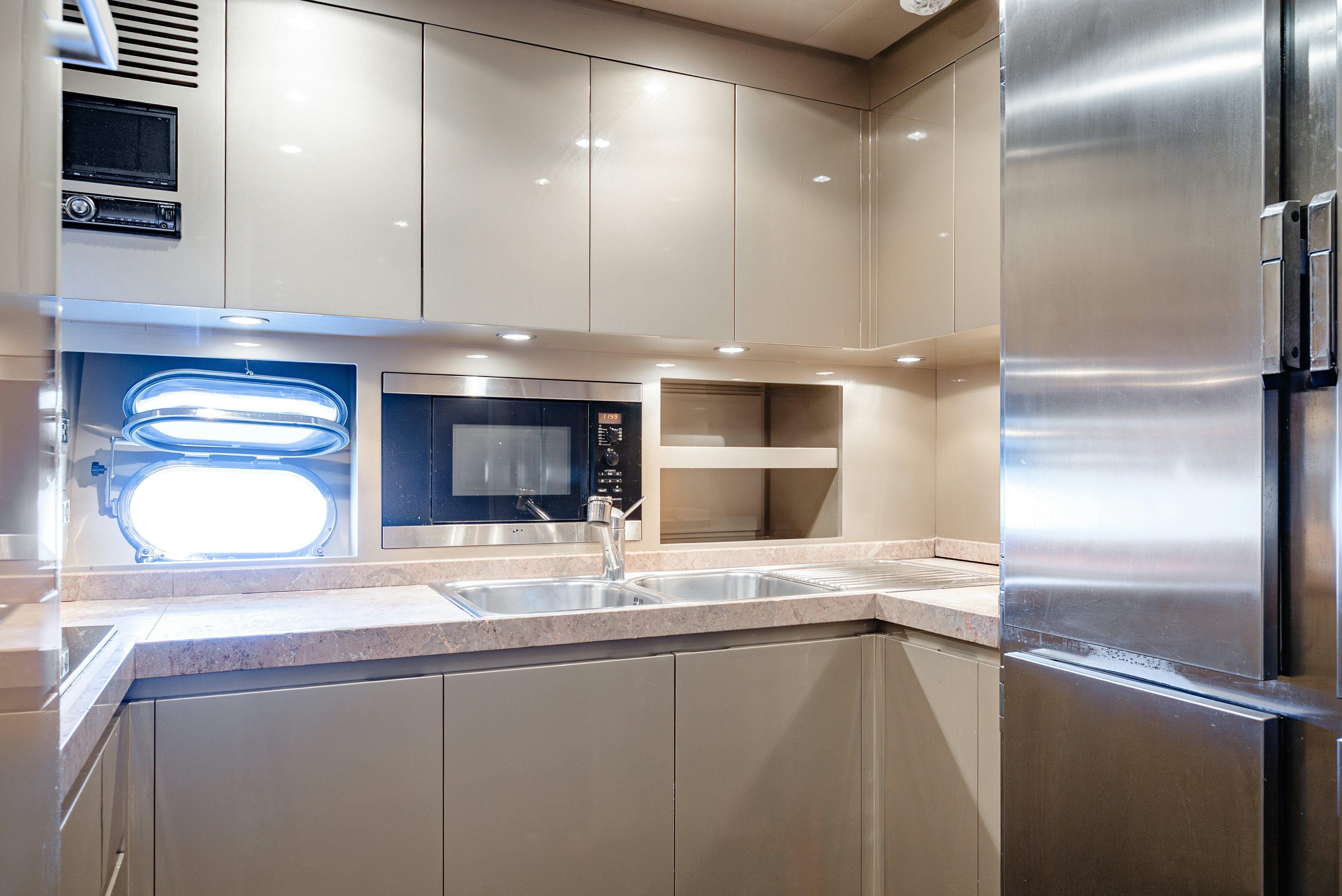 a kitchen with a stainless steel refrigerator aboard CLARITA Yacht for Sale