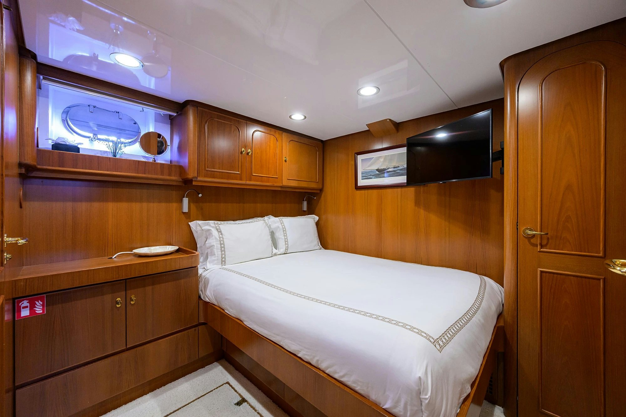 a bedroom with wooden cabinets aboard AVENTURER Yacht for Sale