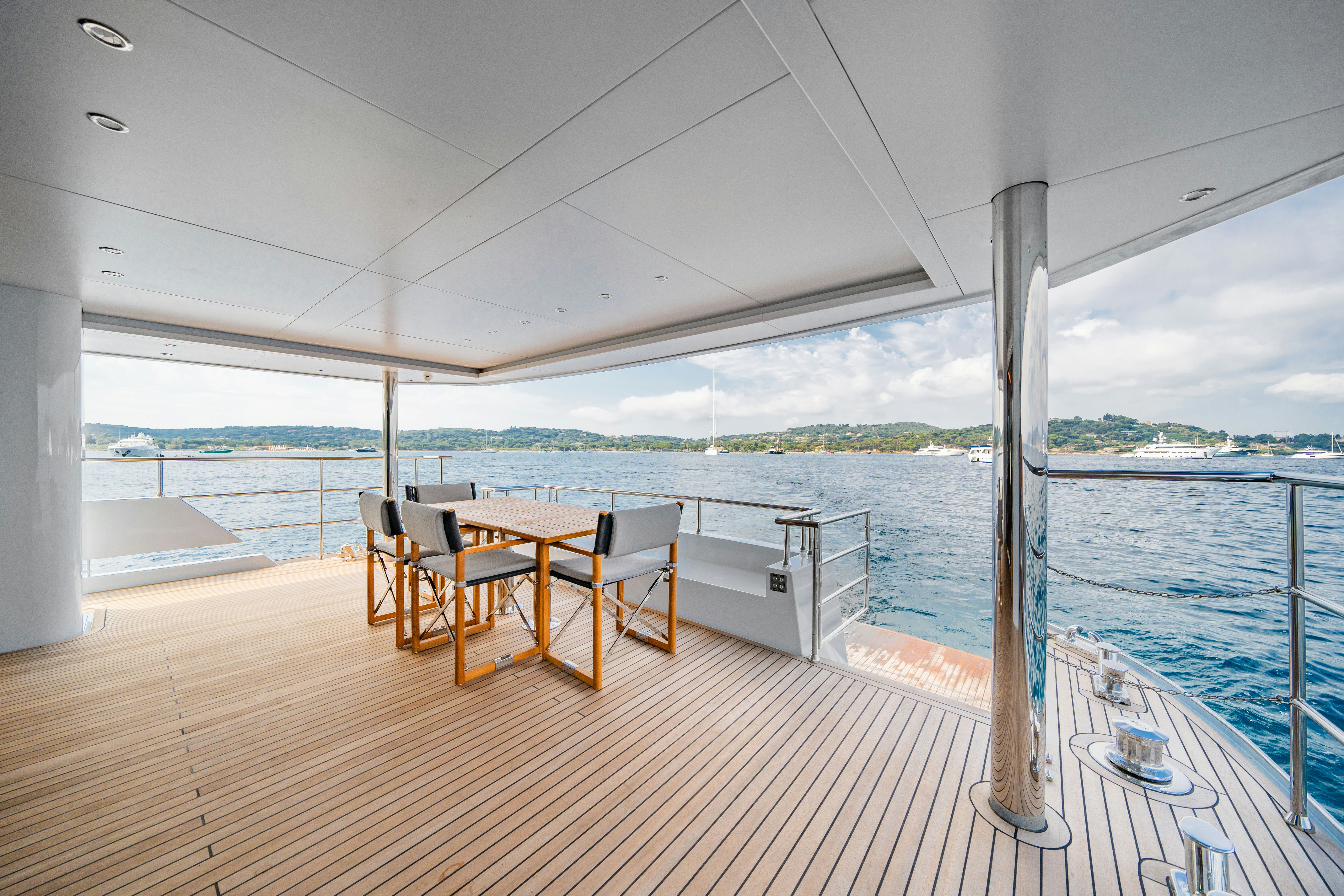 a table and chairs on a deck aboard ICE Yacht for Sale