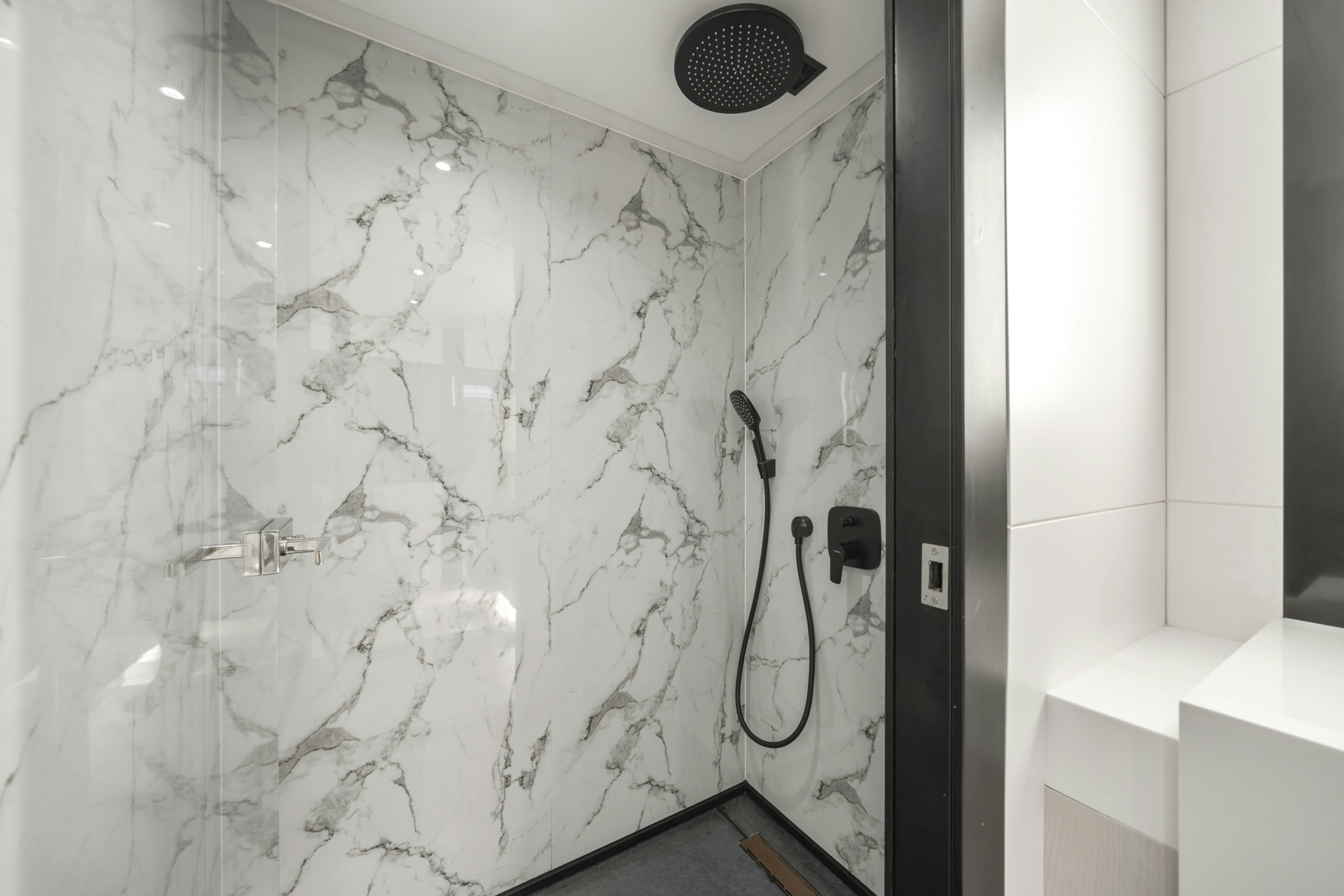 a shower with a white wall aboard ICE Yacht for Sale
