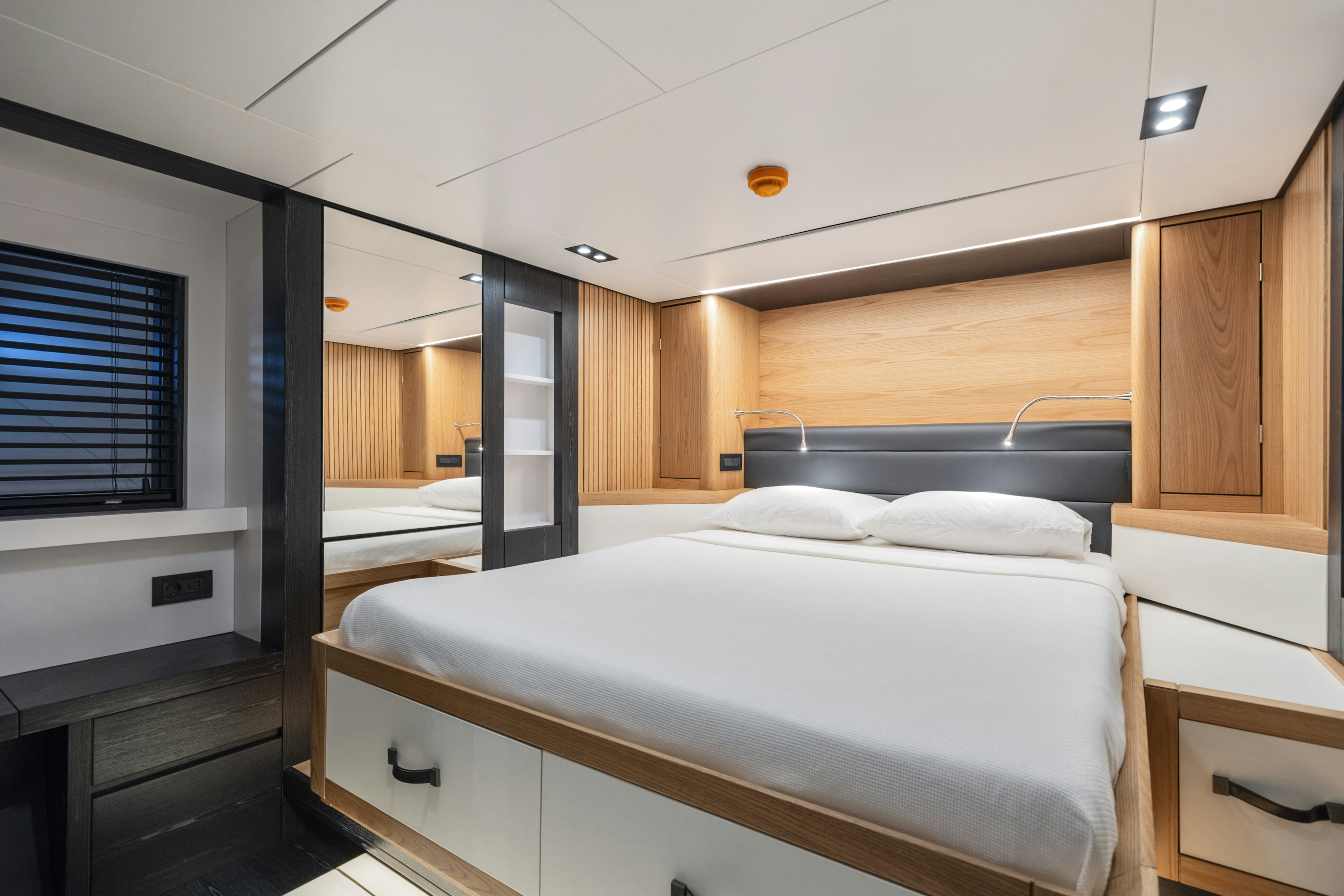a room with a bed and a window aboard ICE Yacht for Sale