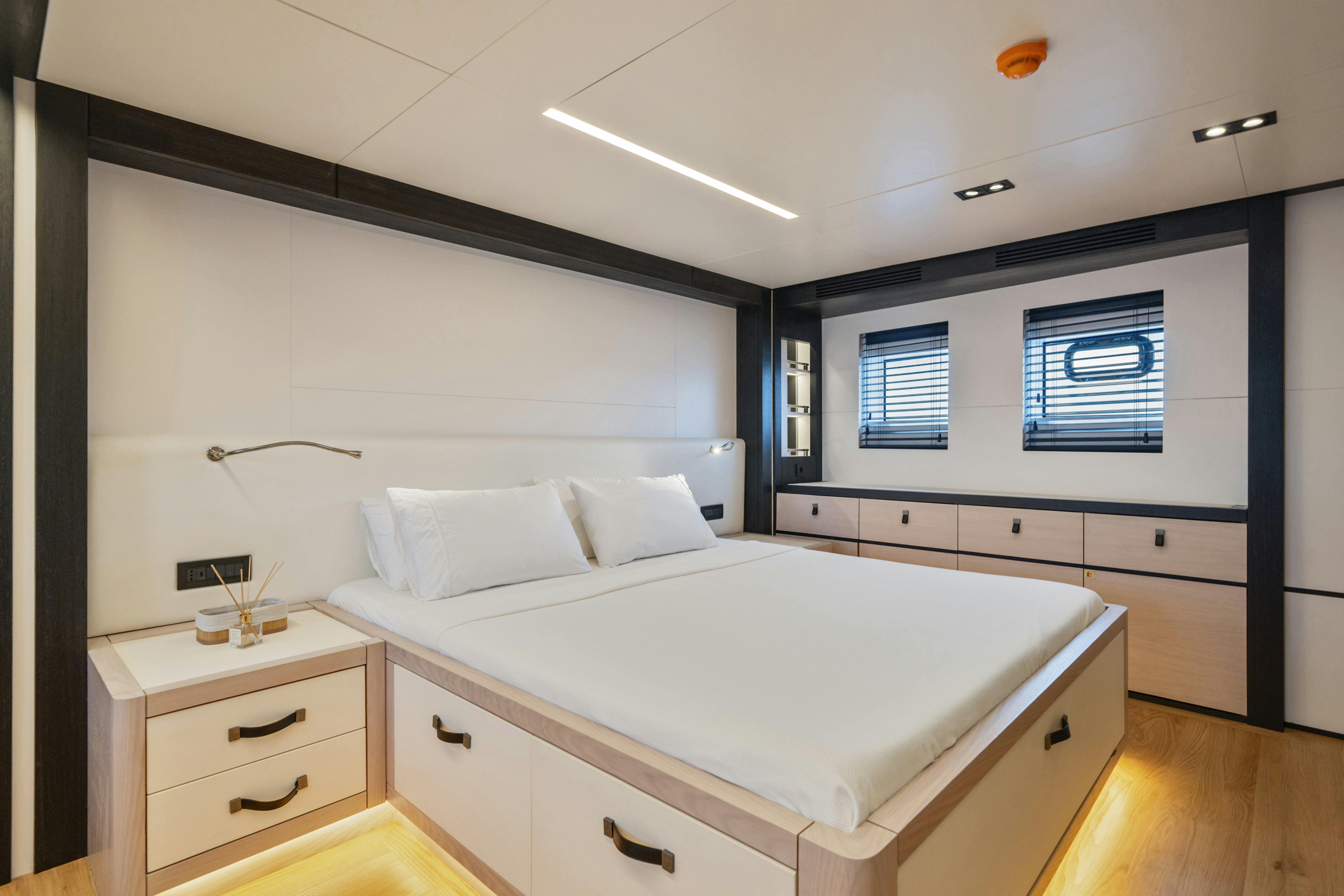 a bedroom with a bed and a window aboard ICE Yacht for Sale