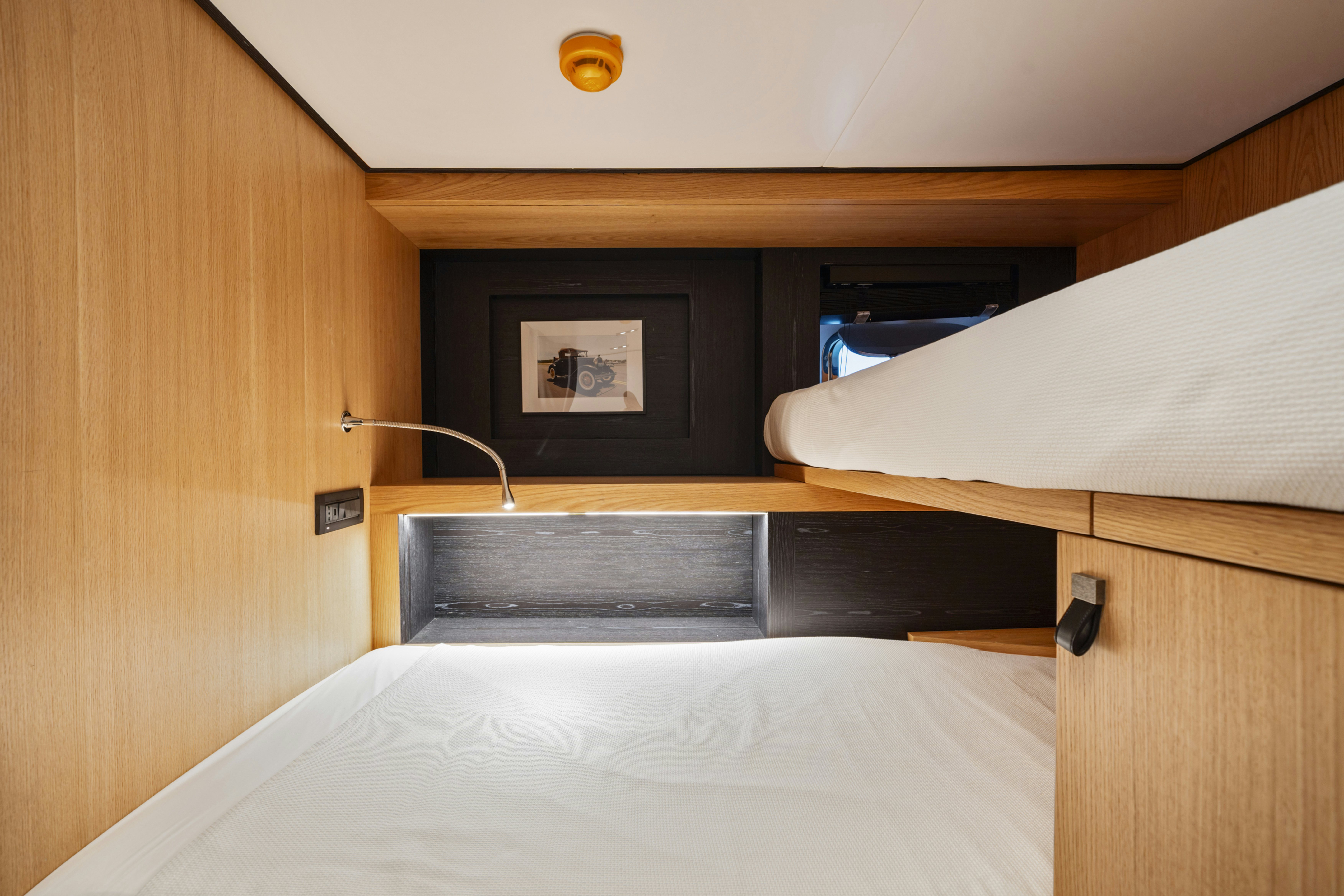 a bed with a desk and a television on it aboard ICE Yacht for Sale