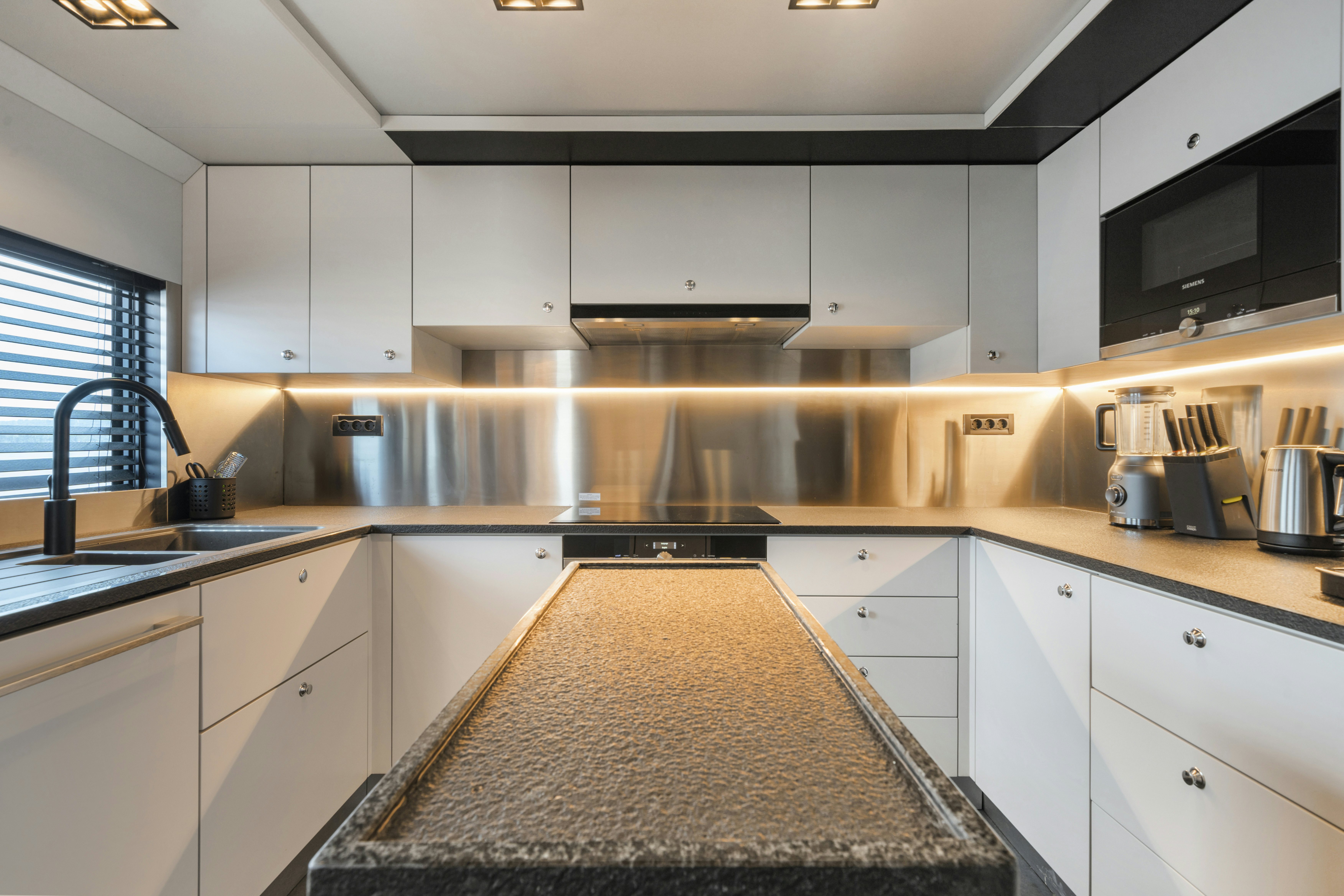 a kitchen with white cabinets aboard ICE Yacht for Sale