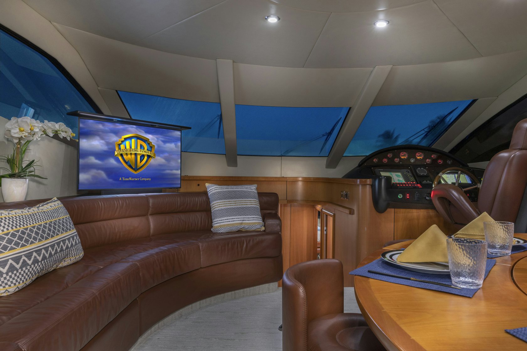a room with a couch and a table with a television on it aboard UNFORGETTABLE Yacht for Charter