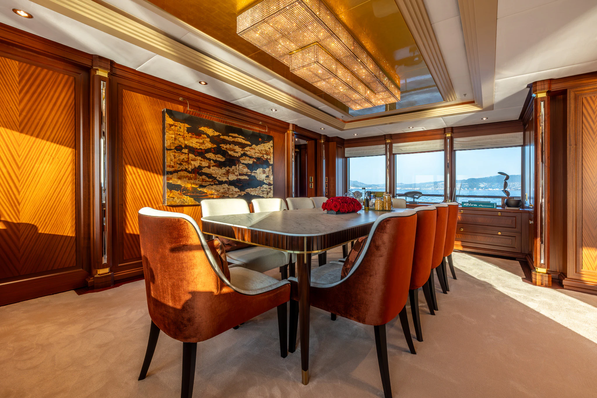 a dining table and chairs in a room with a large window aboard LADY MAXINE Yacht for Sale