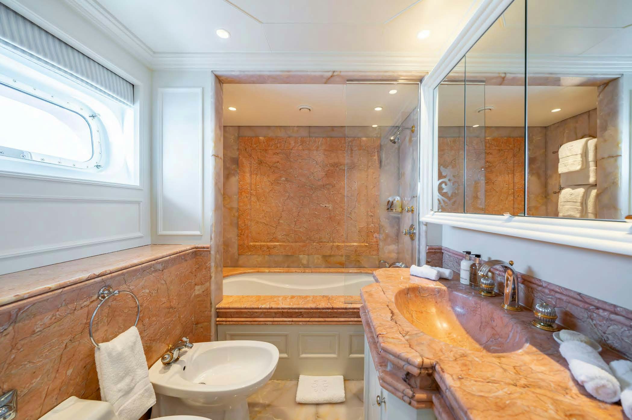 a bathroom with a countertop sink and a bathtub aboard MOSAIQUE Yacht for Sale