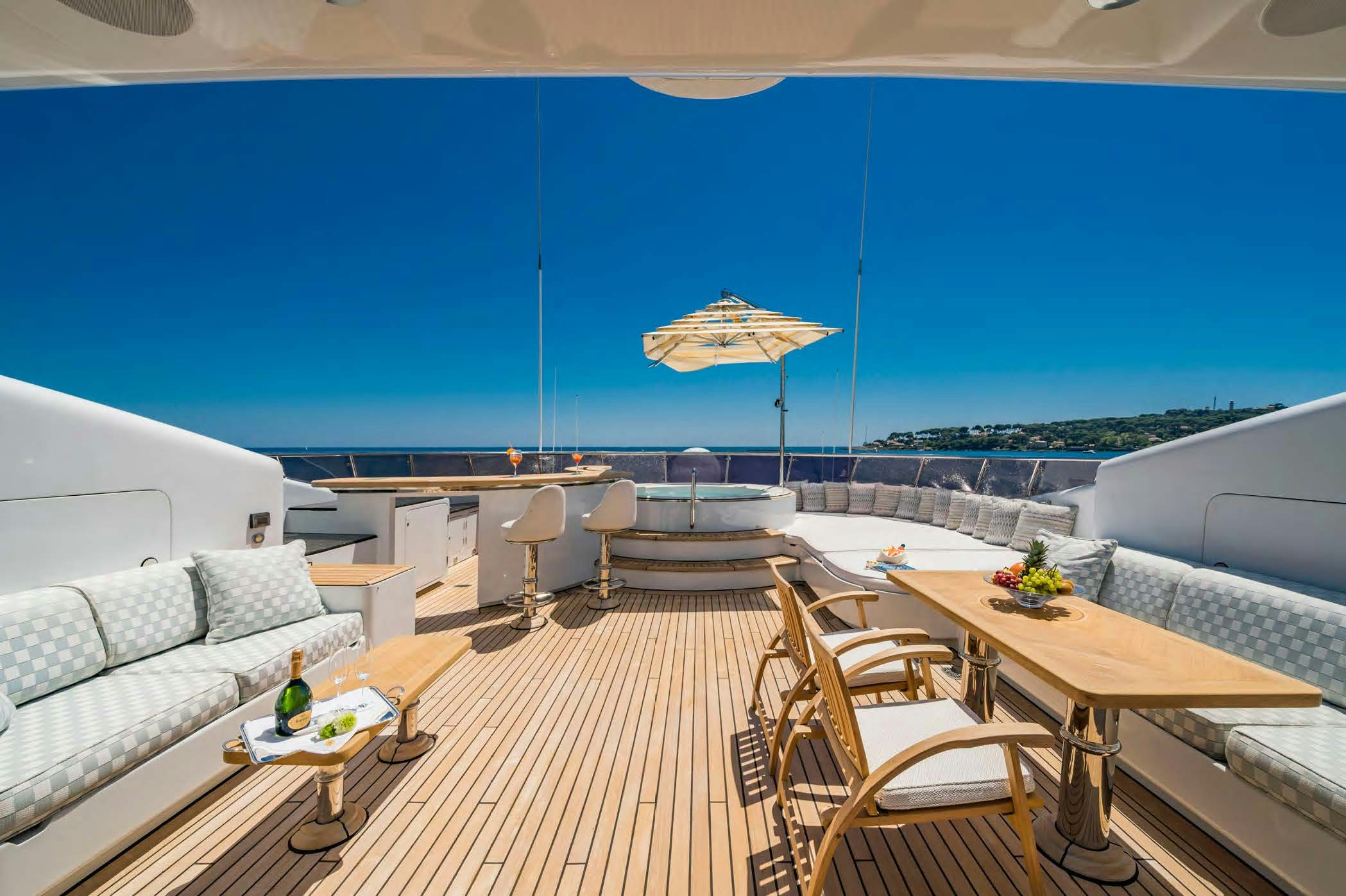 a deck with a table and chairs on it aboard MOSAIQUE Yacht for Sale