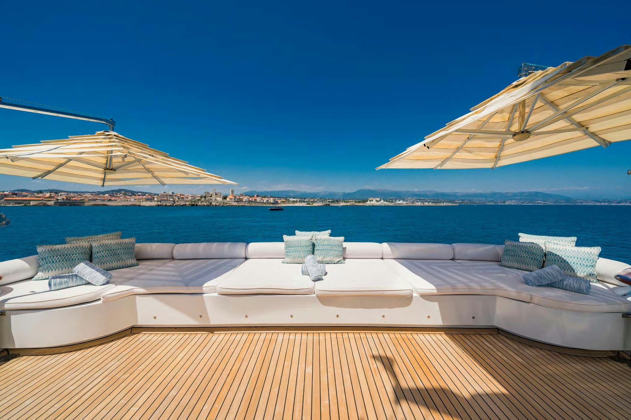a pool with a lounge chair and umbrellas on a sunny day aboard MOSAIQUE Yacht for Sale