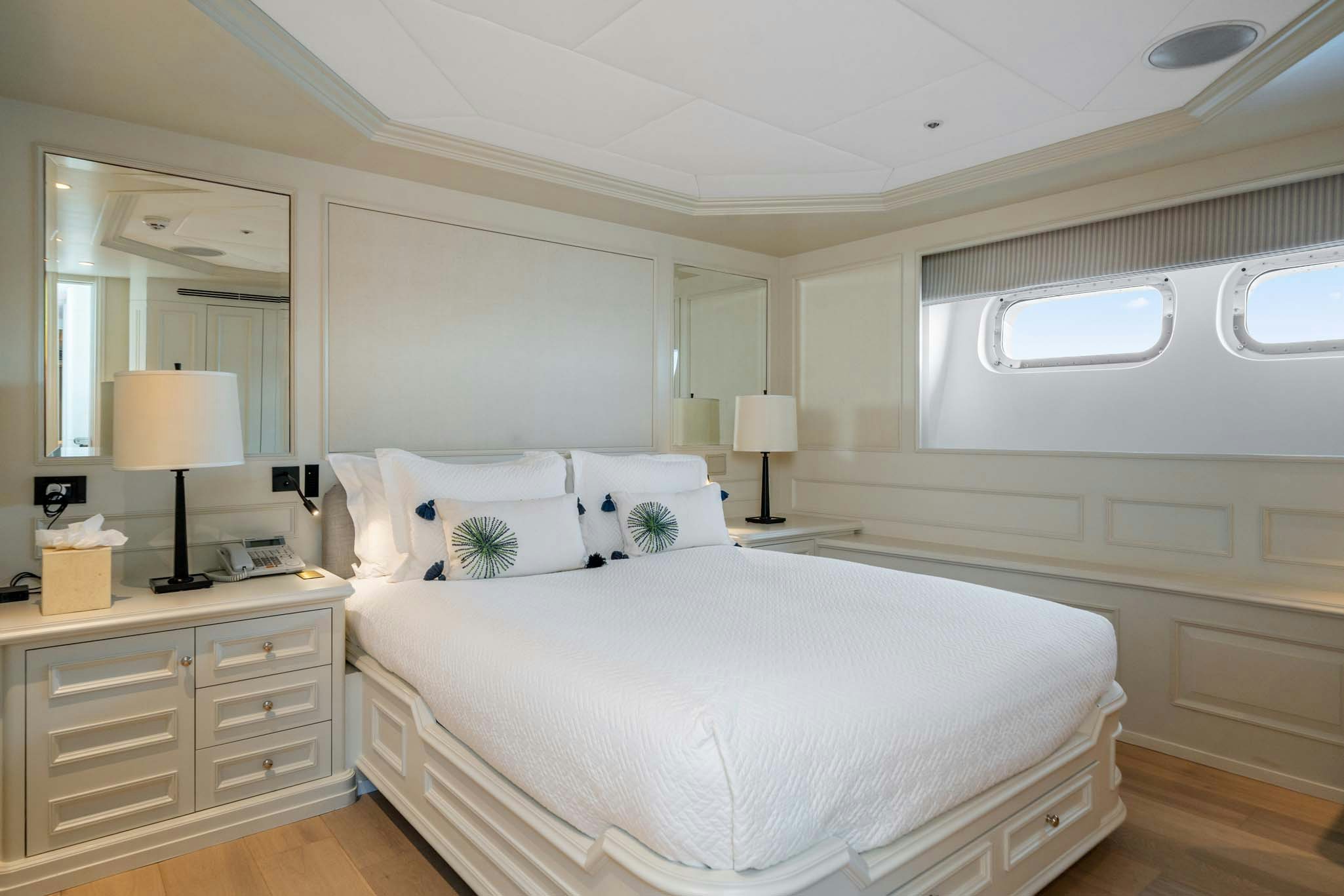 a bedroom with a bed and a mirror aboard MOSAIQUE Yacht for Charter