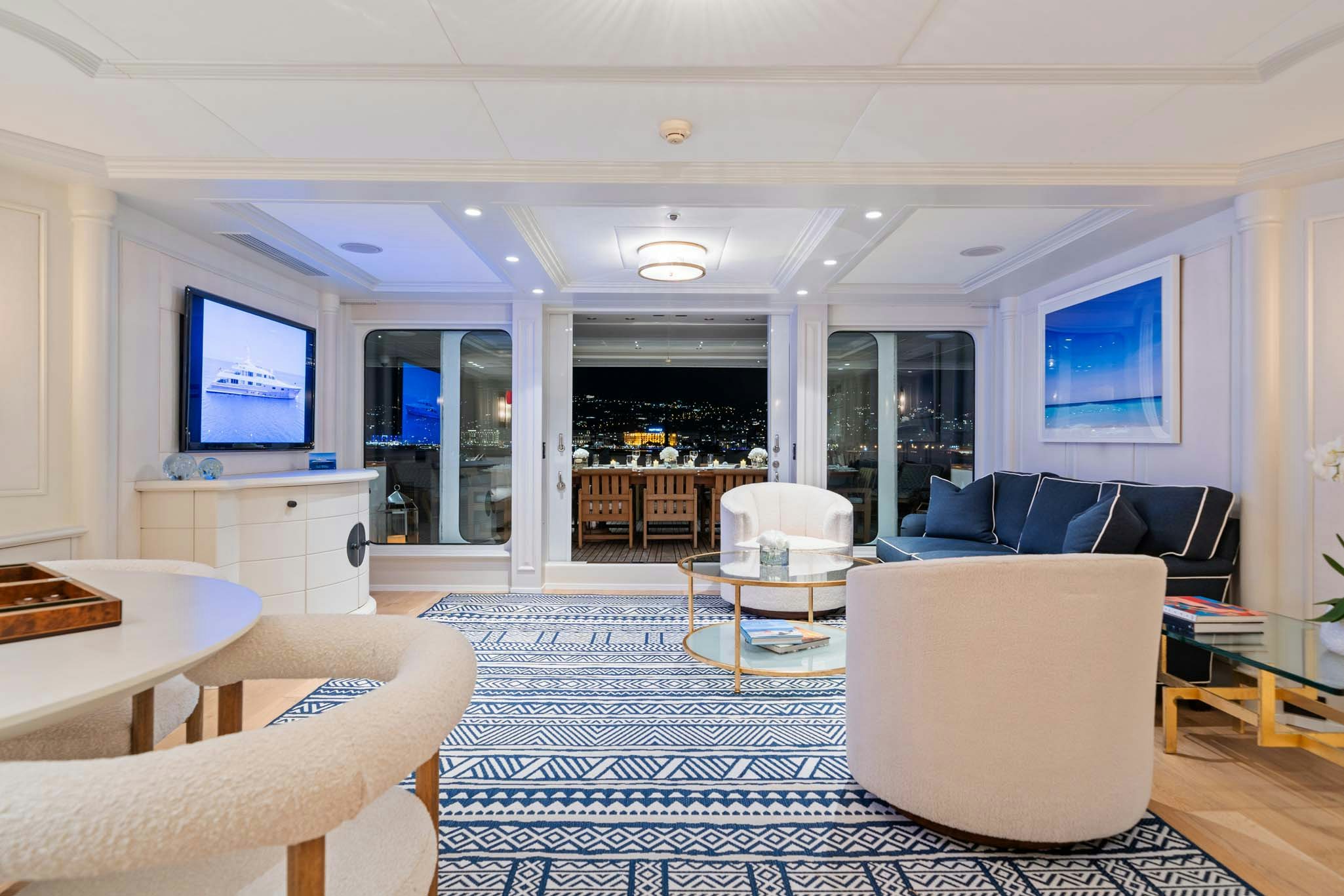 a living room with a large blue rug and a large window aboard MOSAIQUE Yacht for Charter