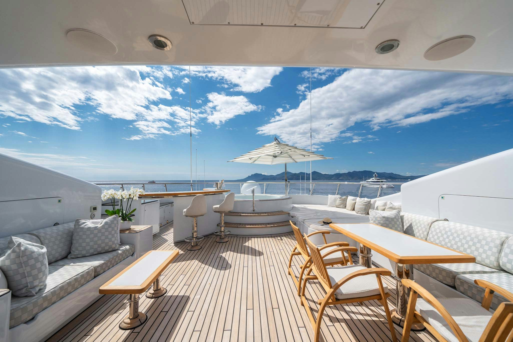 a deck with a table and chairs on it aboard MOSAIQUE Yacht for Charter