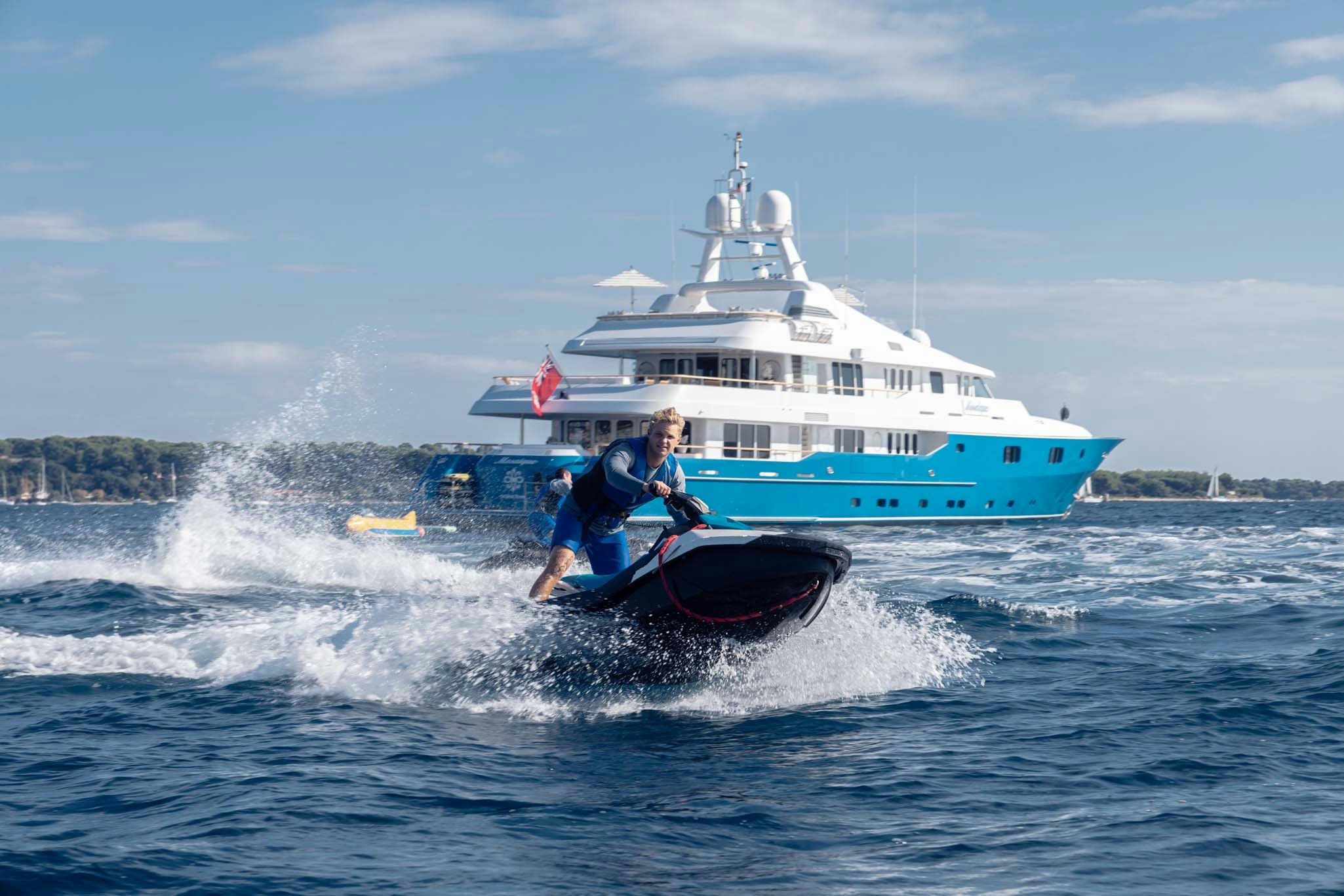 a man on a jet ski in the water with a boat in the background aboard MOSAIQUE Yacht for Charter