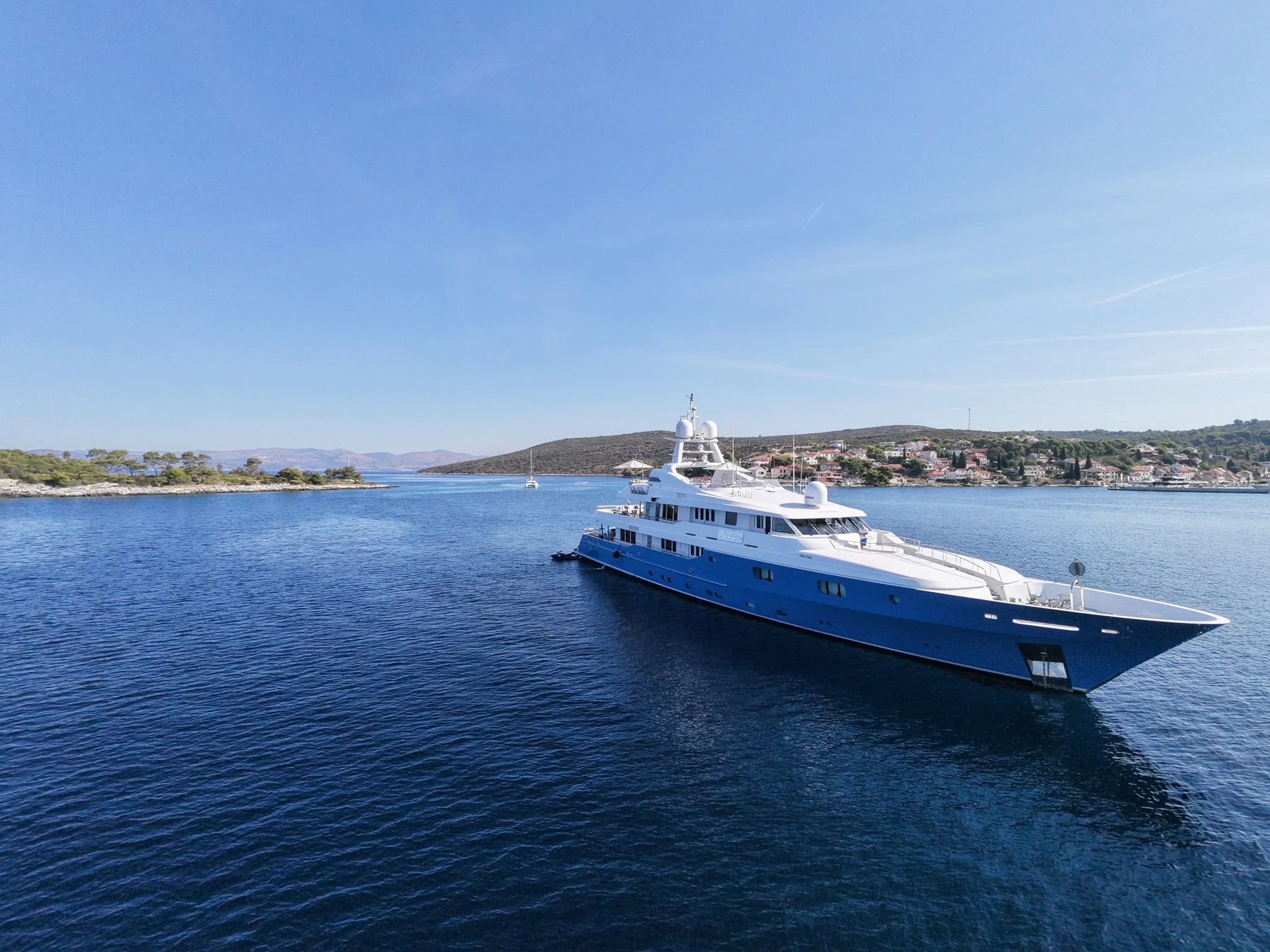 a large white boat in the water aboard MOSAIQUE Yacht for Charter