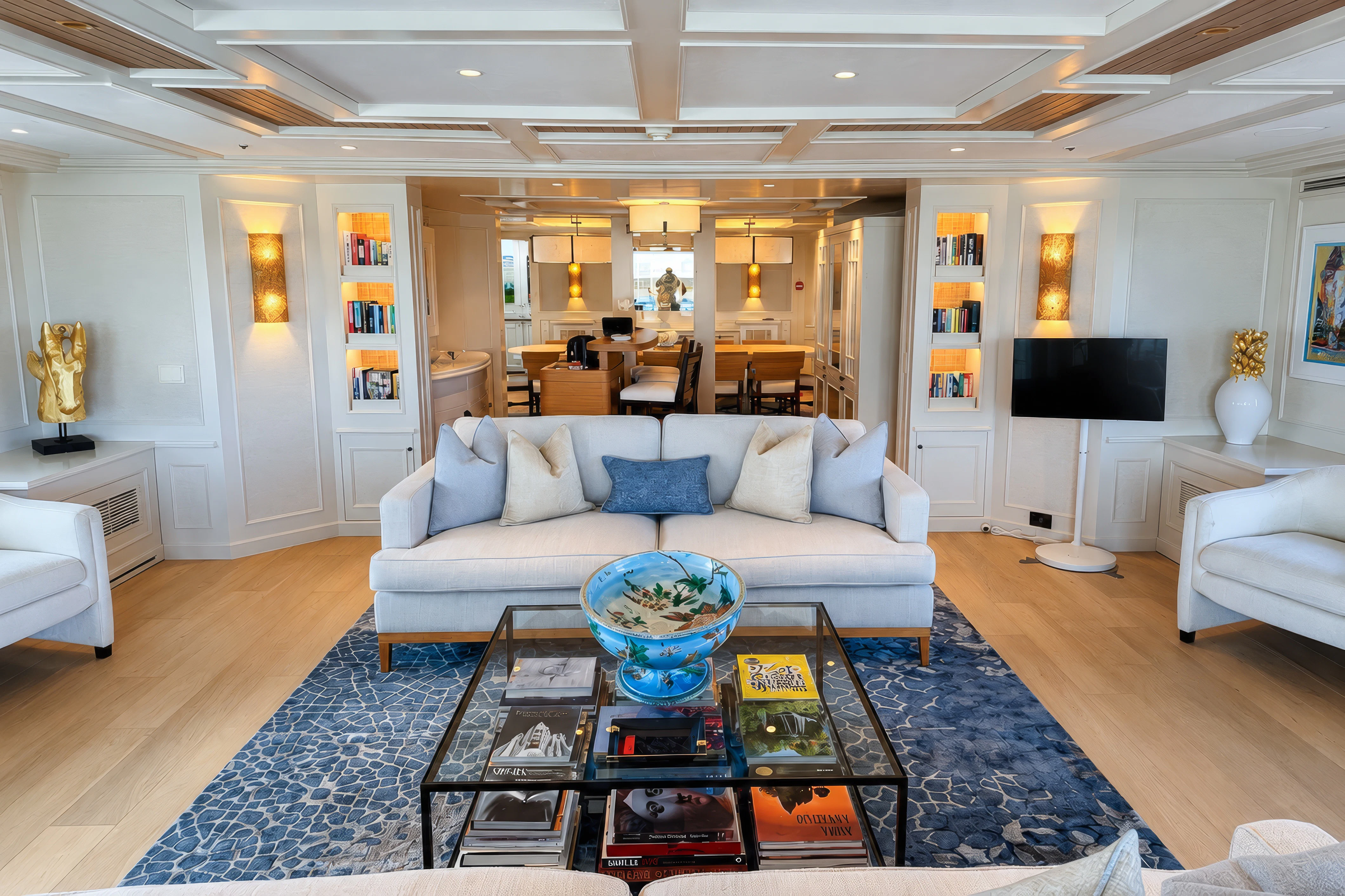 a living room with a blue couch aboard MOSAIQUE Yacht for Charter