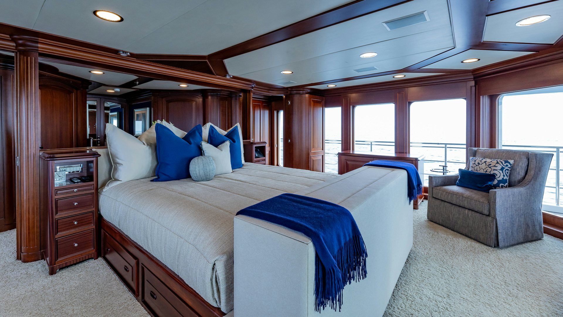 a bedroom with a large bed and a chair aboard FOCUS Yacht for Sale