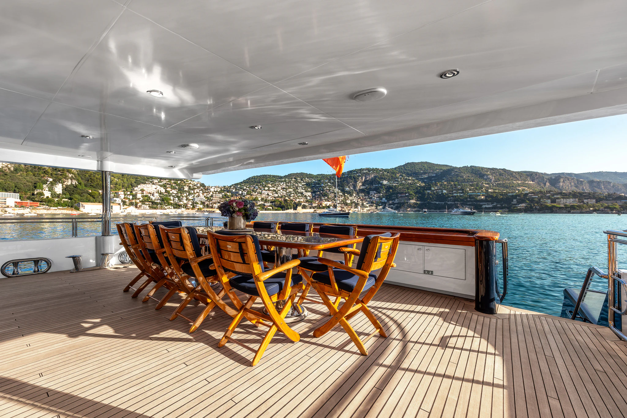 a deck with chairs and a table on it aboard KAJAK Yacht for Sale
