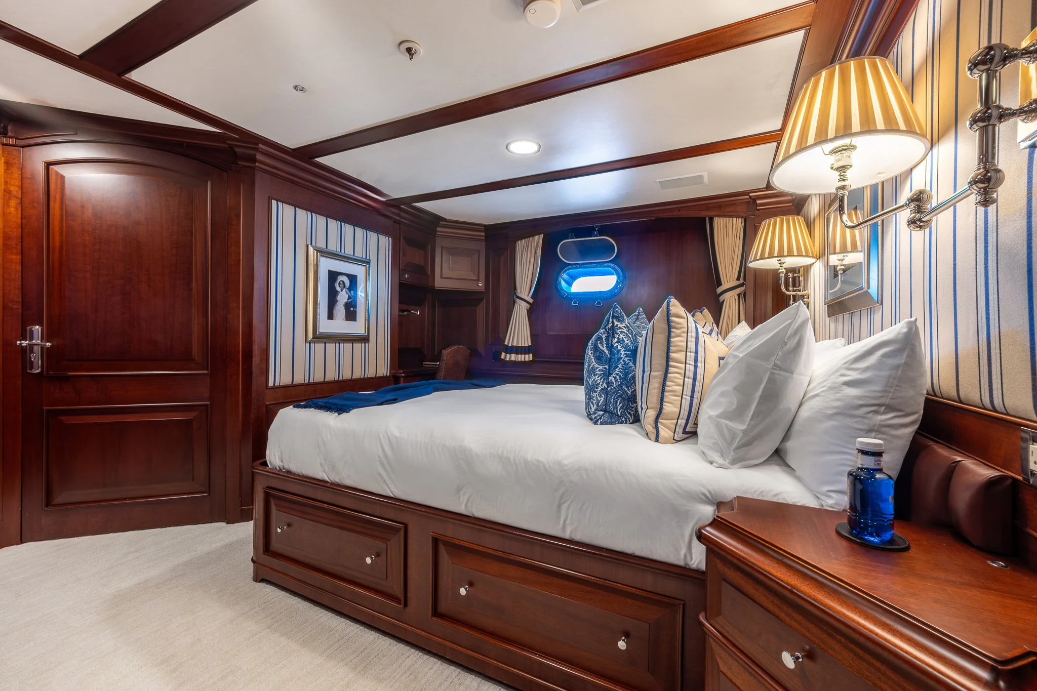 a bedroom with a bed and a dresser aboard KAJAK Yacht for Sale