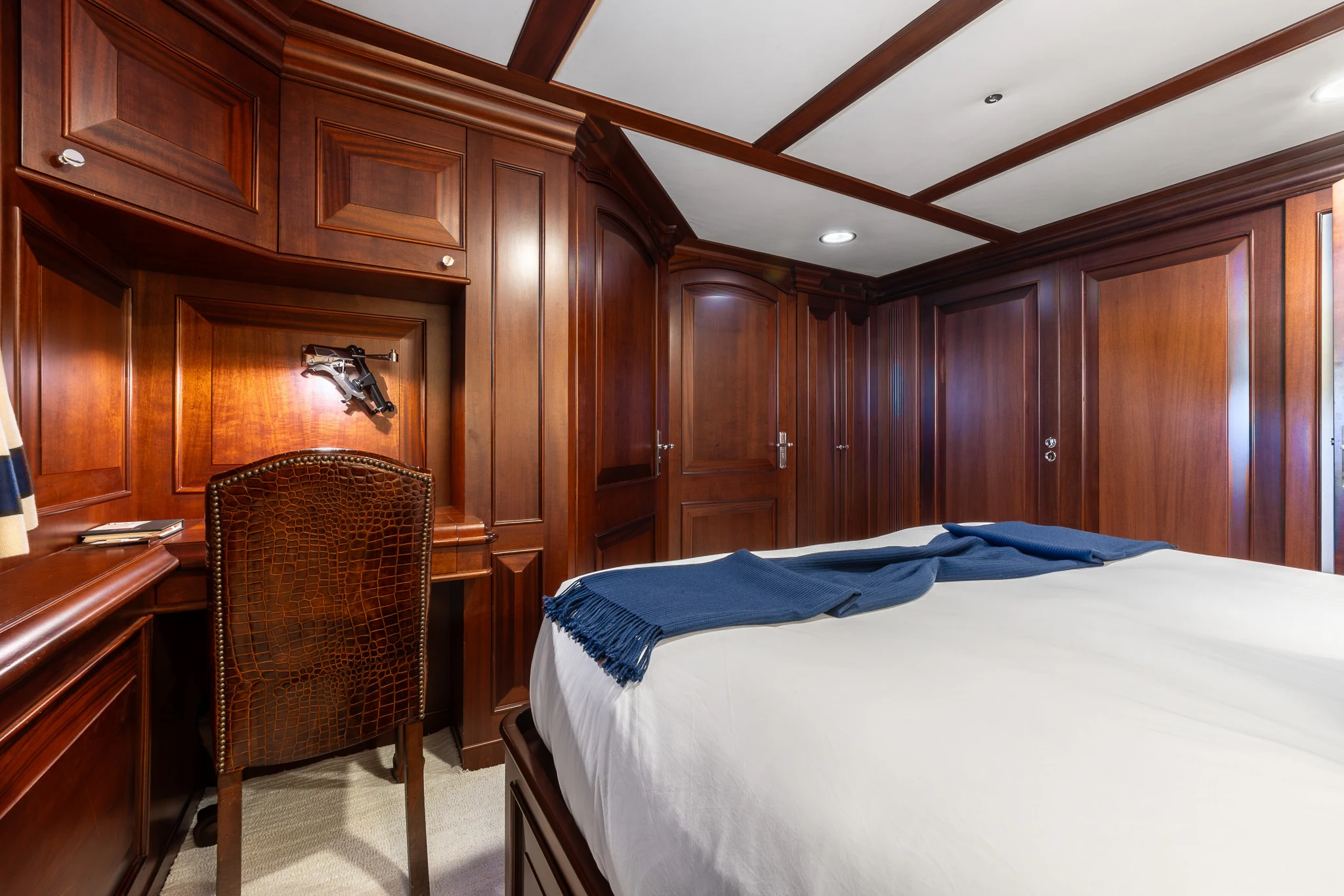 a bedroom with a bed and a chair aboard KAJAK Yacht for Sale