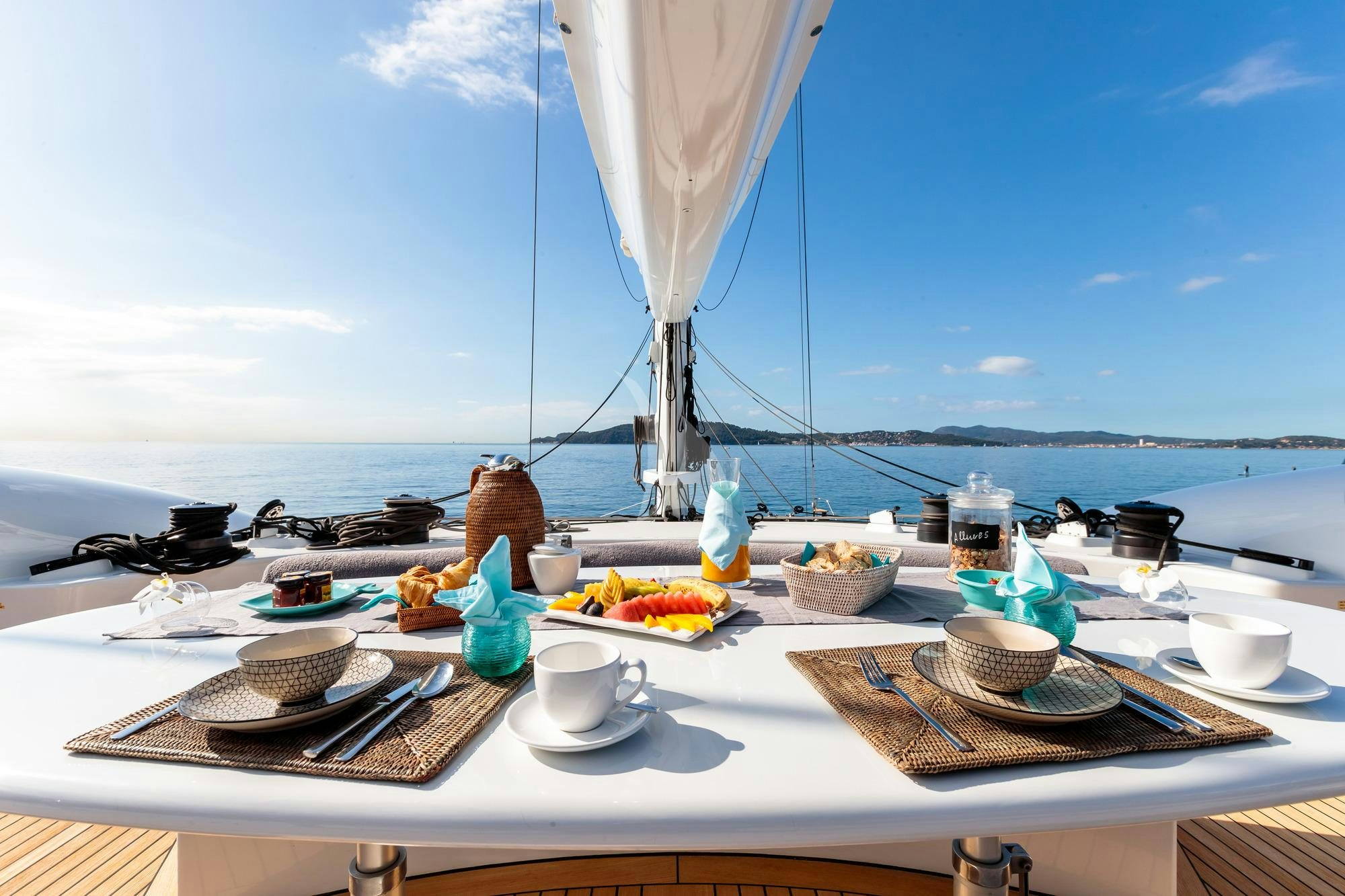 a table with plates and food on it aboard ALLURES Yacht for Charter