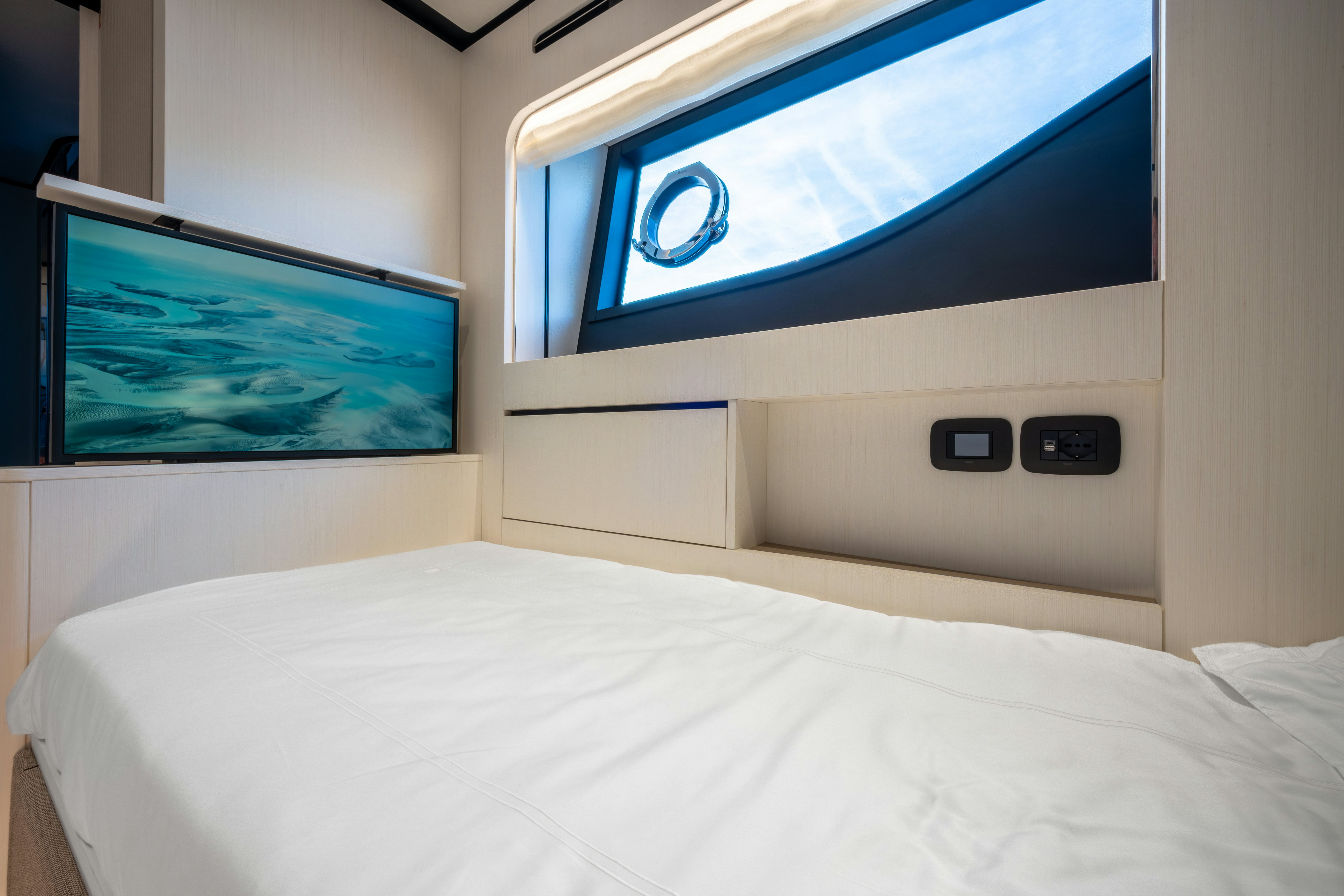 a bed with a screen on the wall aboard TOGETHER Yacht for Sale