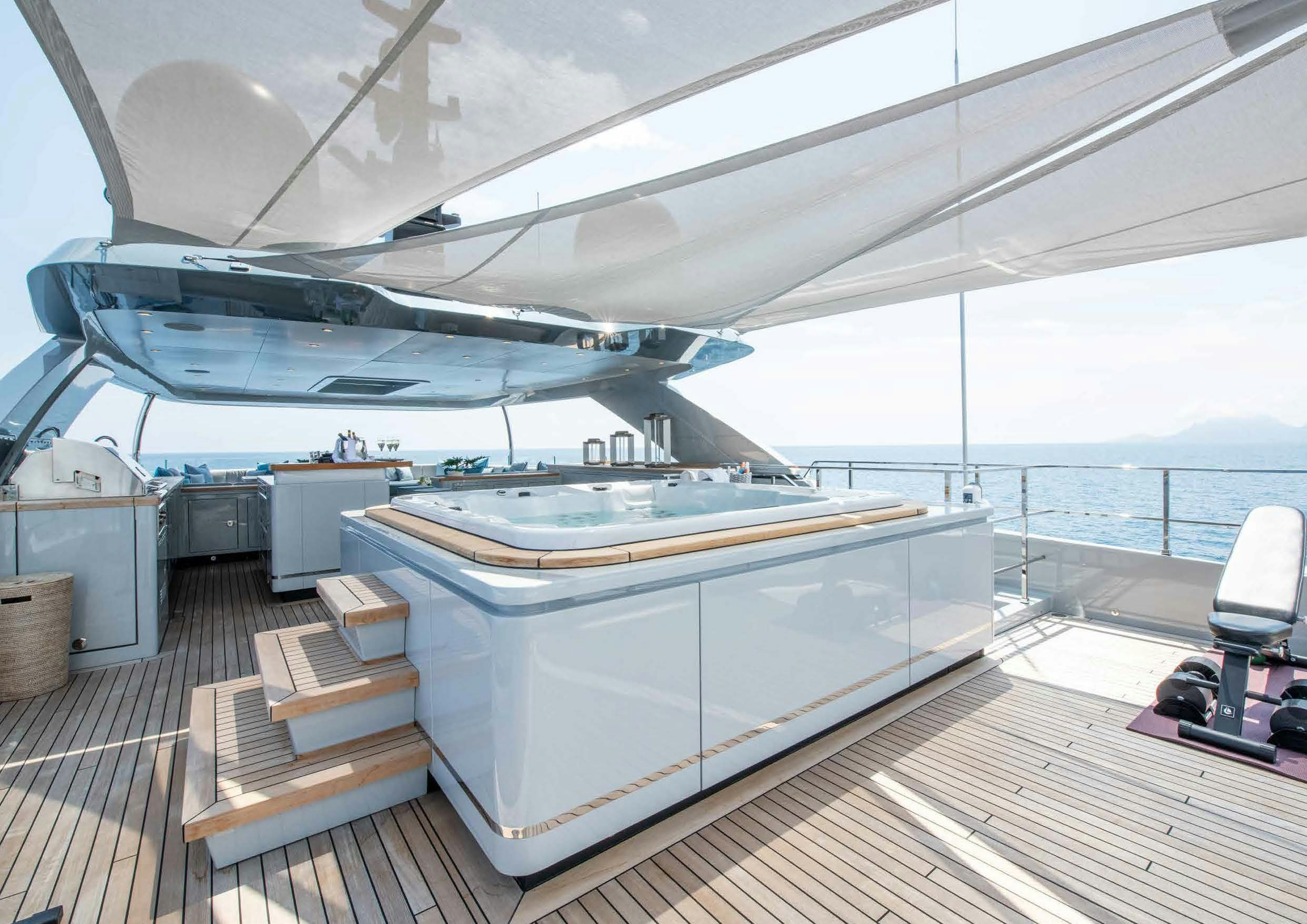a deck with a table and chairs aboard NURI Yacht for Charter