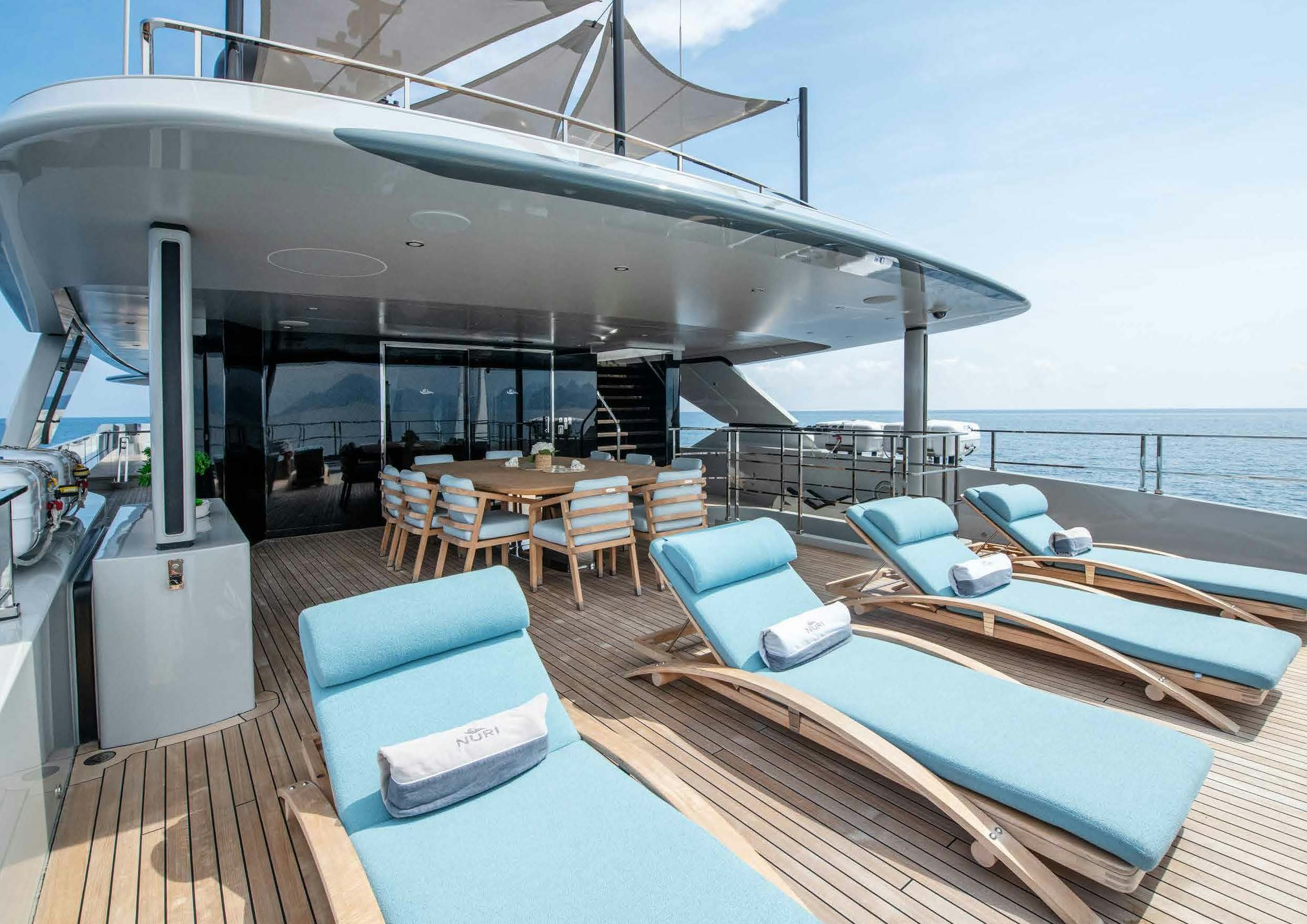 a large pool with a deck and chairs on the deck aboard NURI Yacht for Charter
