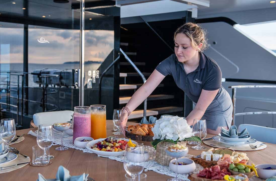 a person preparing food on a table aboard NURI Yacht for Charter