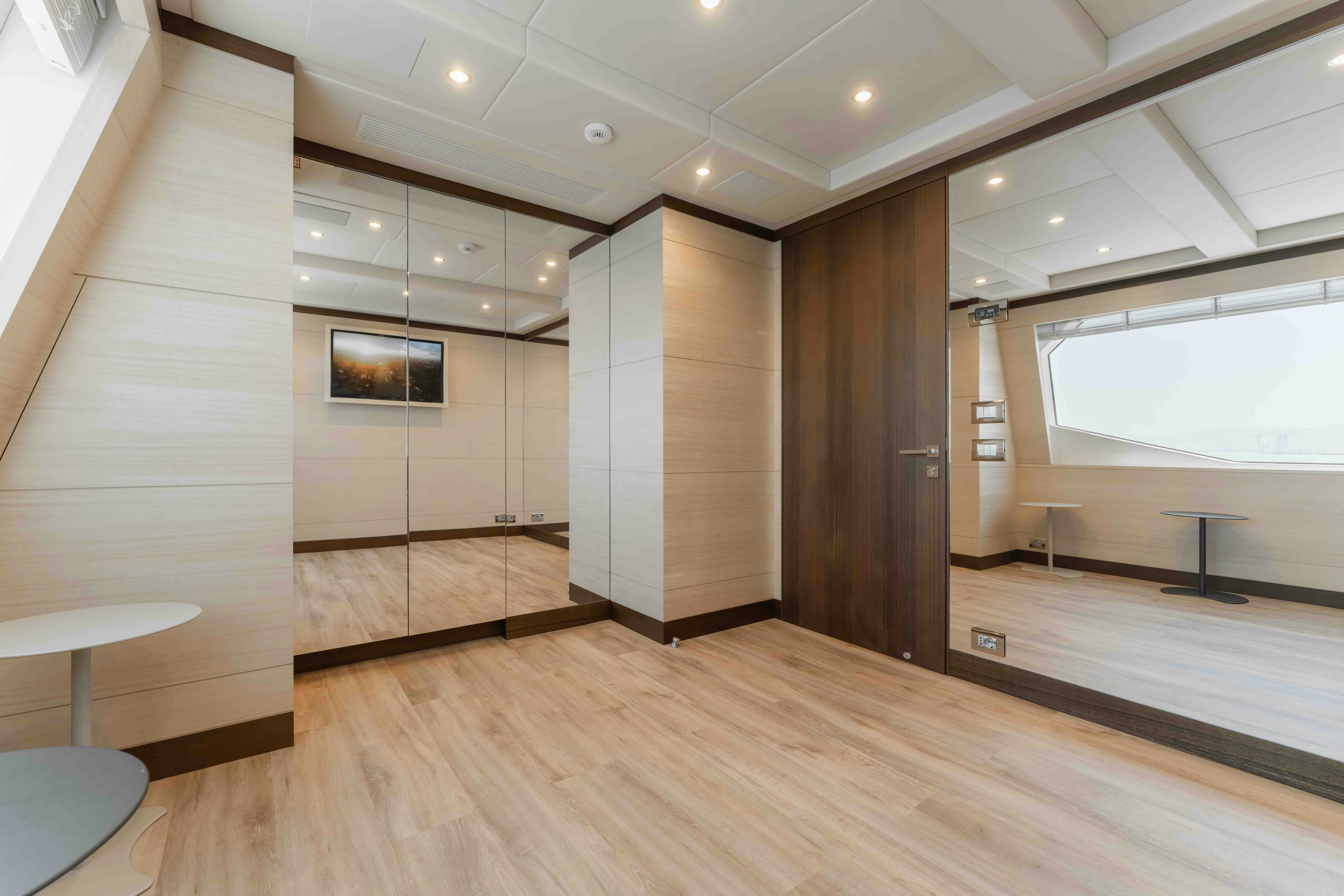 a room with a wood floor and a large window aboard EXINITY Yacht for Sale