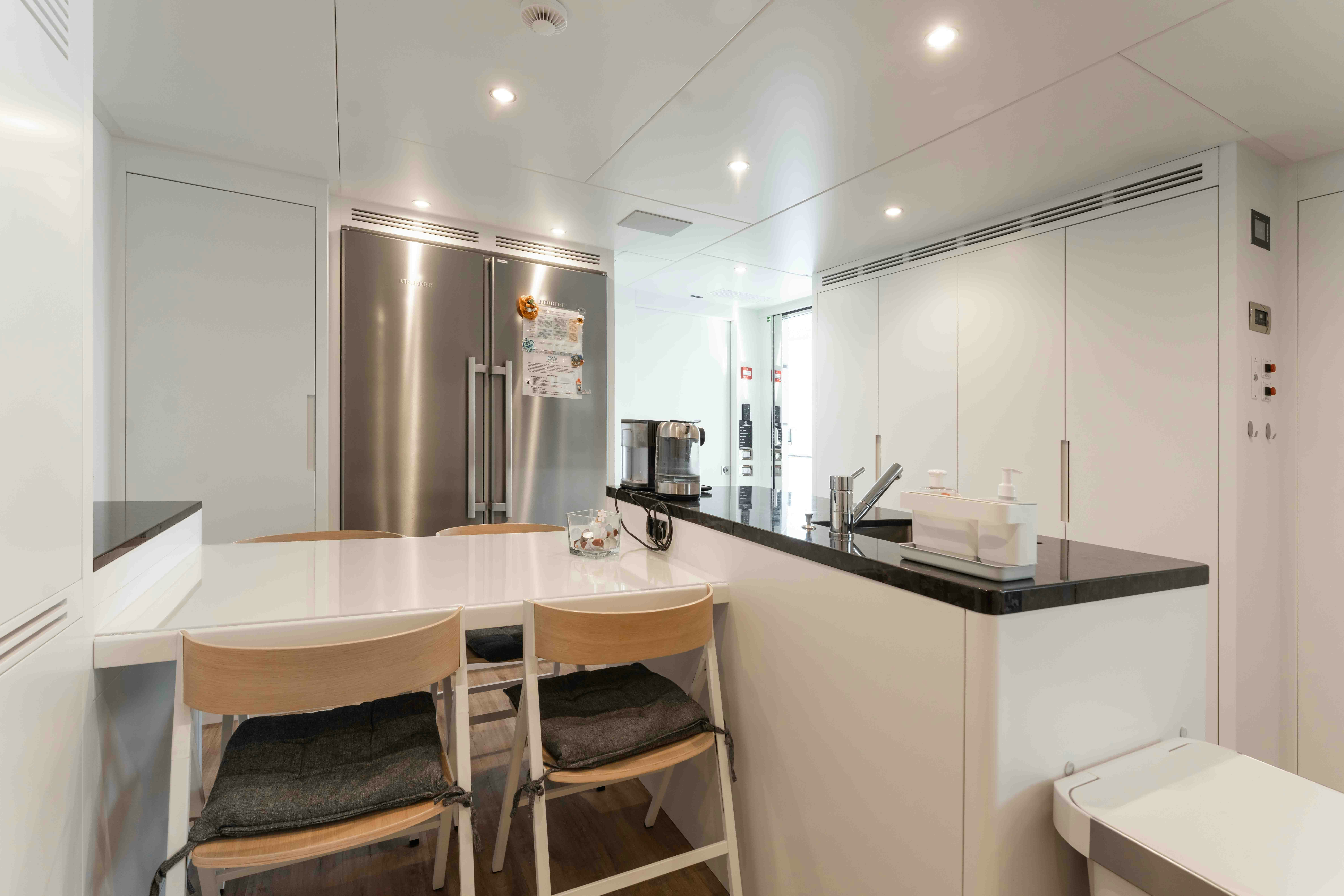 a kitchen with a table and chairs aboard EXINITY Yacht for Sale