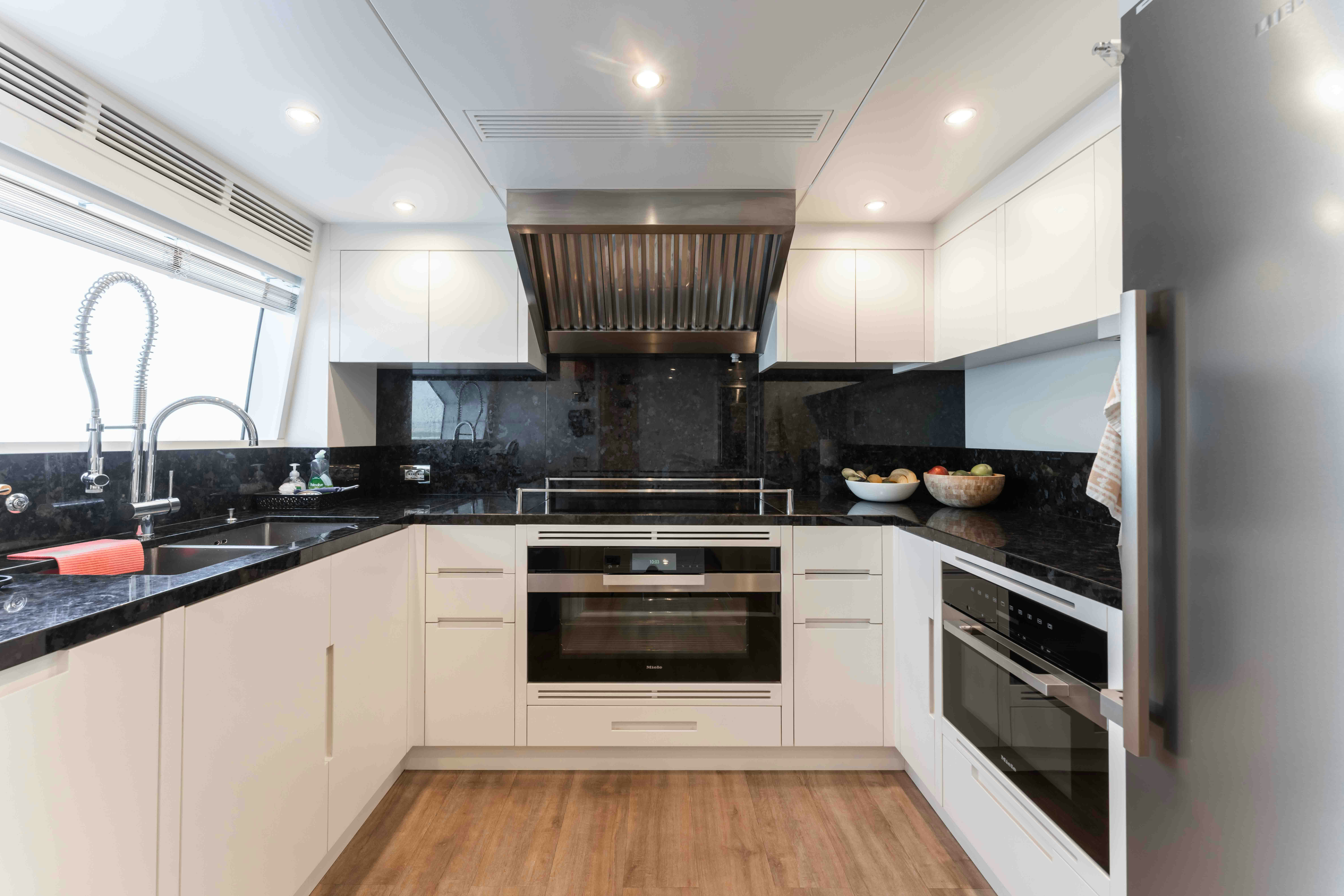 a kitchen with white cabinets aboard EXINITY Yacht for Sale