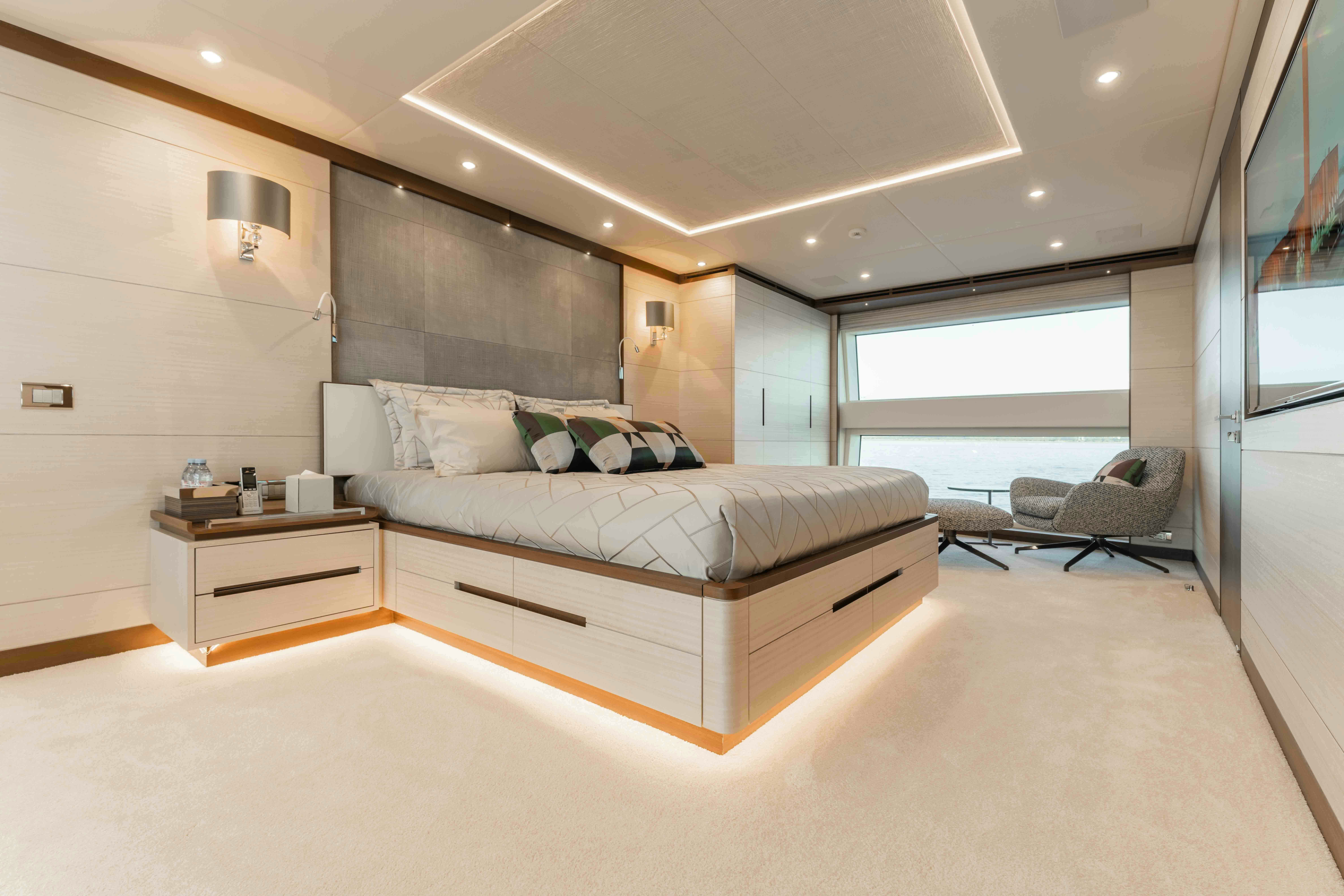 a bedroom with a bed and a chair aboard EXINITY Yacht for Sale