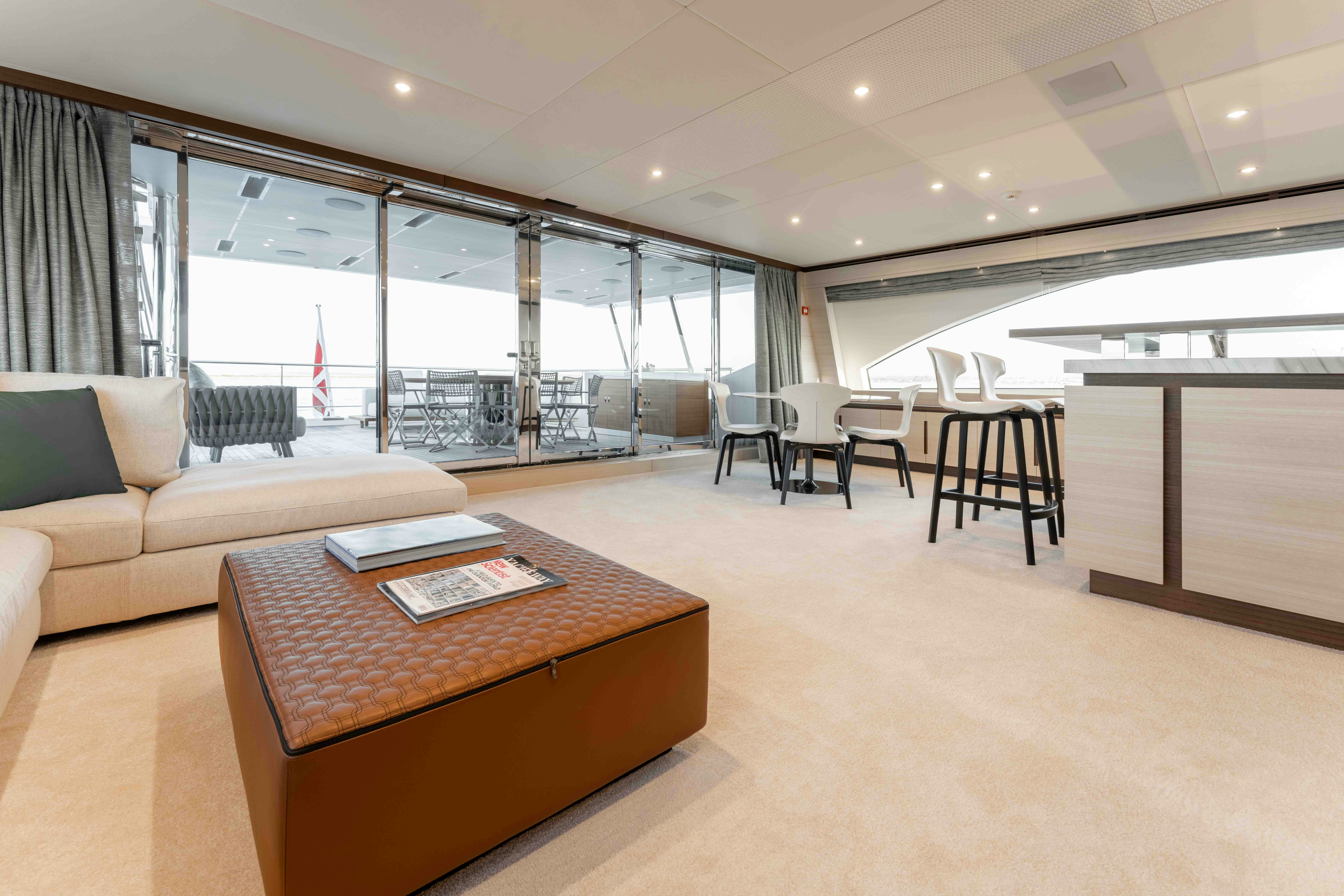 a large living room with a large glass wall aboard EXINITY Yacht for Sale