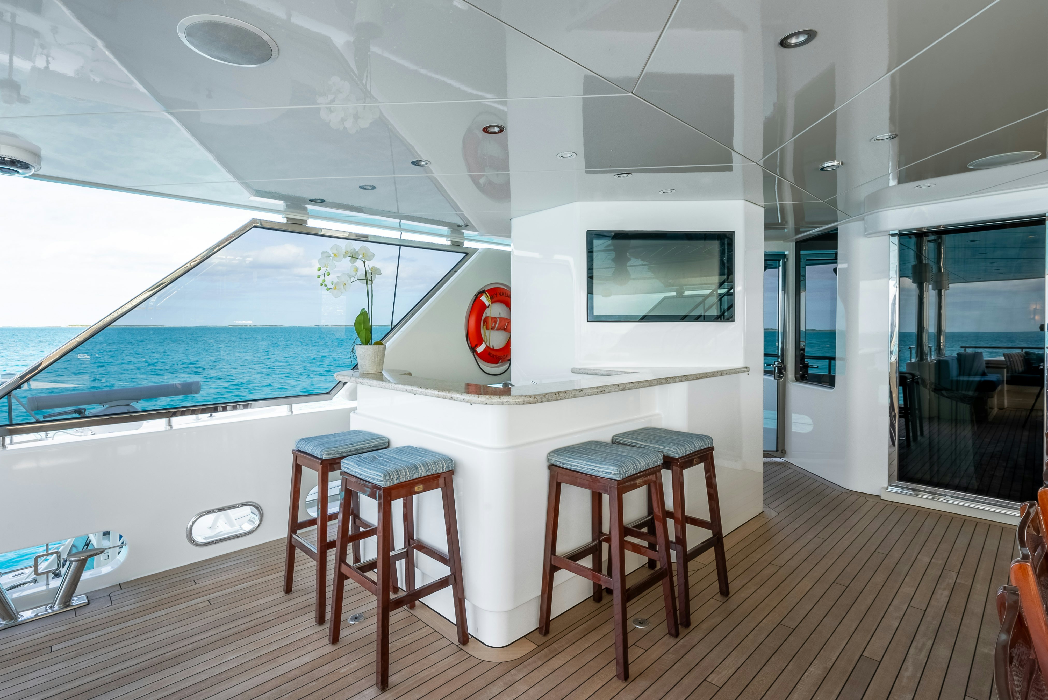 a room with a table and stools and a window aboard VALINOR Yacht for Sale