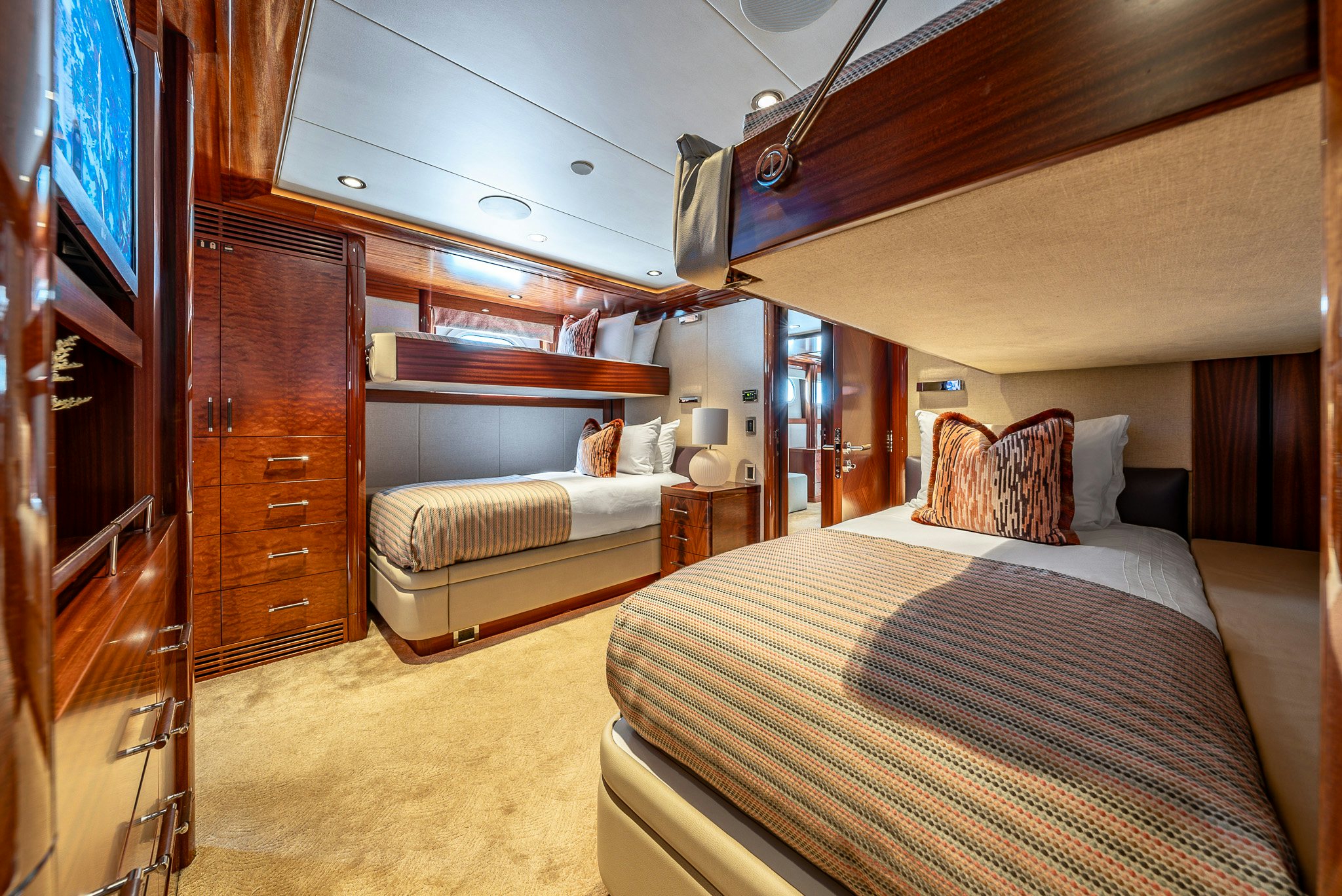 a bedroom with a bed and a wood cabinet aboard VALINOR Yacht for Charter
