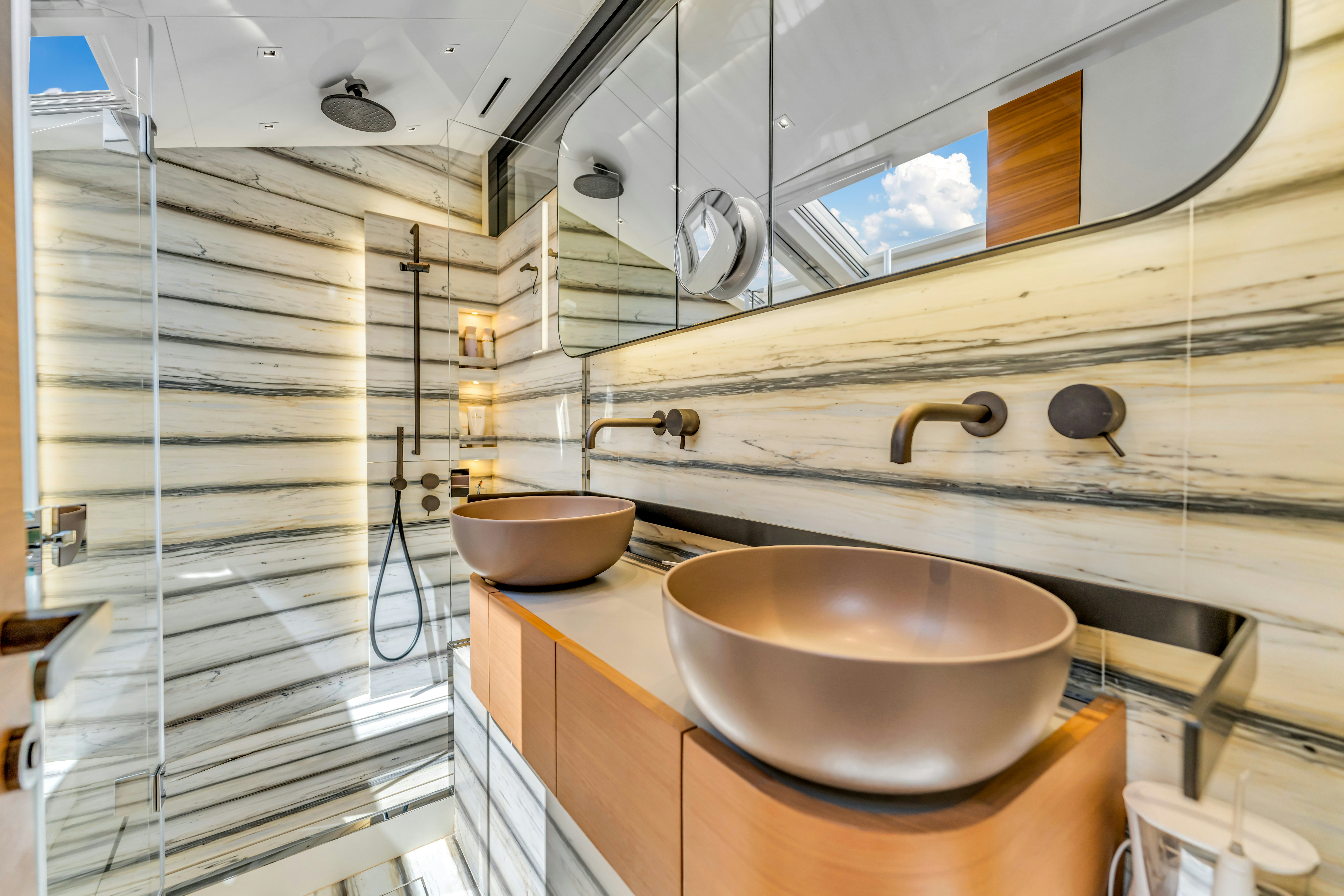a bathroom with a sink and a large mirror aboard NOTYNOG Yacht for Charter