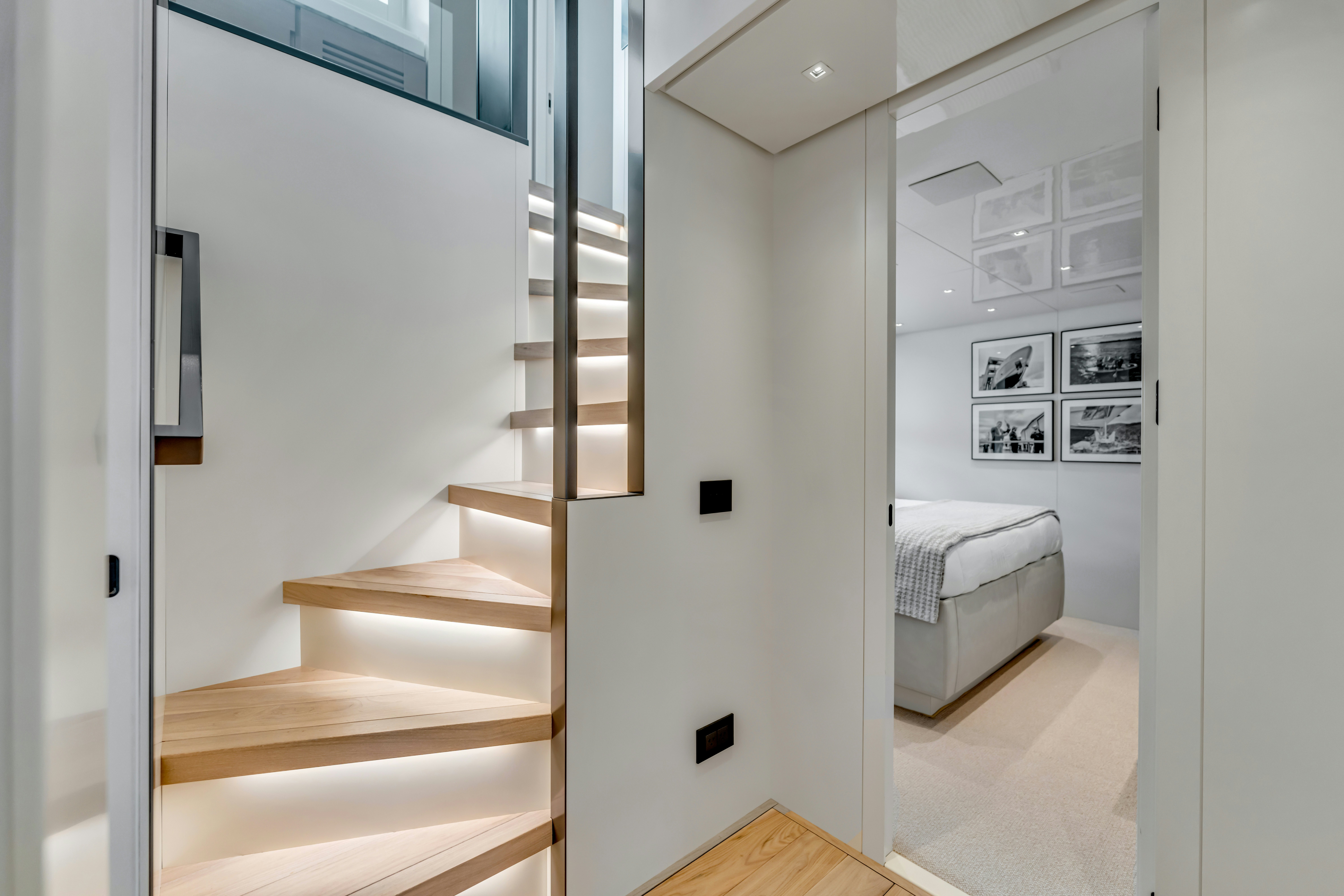 a white room with a staircase and a couch aboard NOTYNOG Yacht for Charter