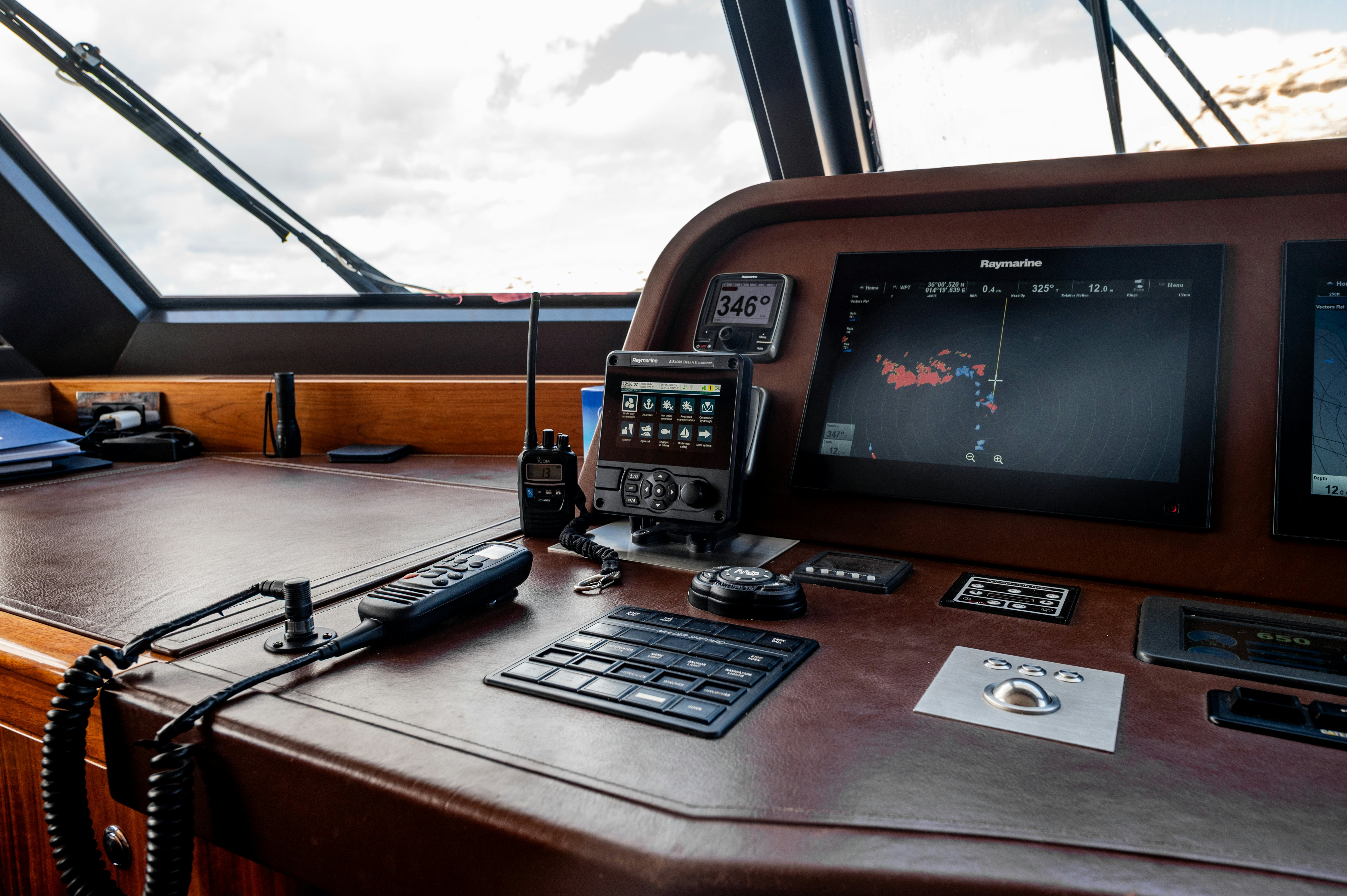a control panel and a monitor on a table aboard FIREFLY Yacht for Sale