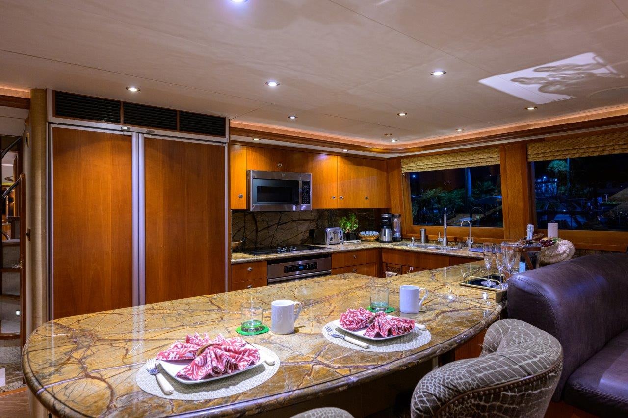a kitchen with a table and chairs aboard EXODUS Yacht for Sale